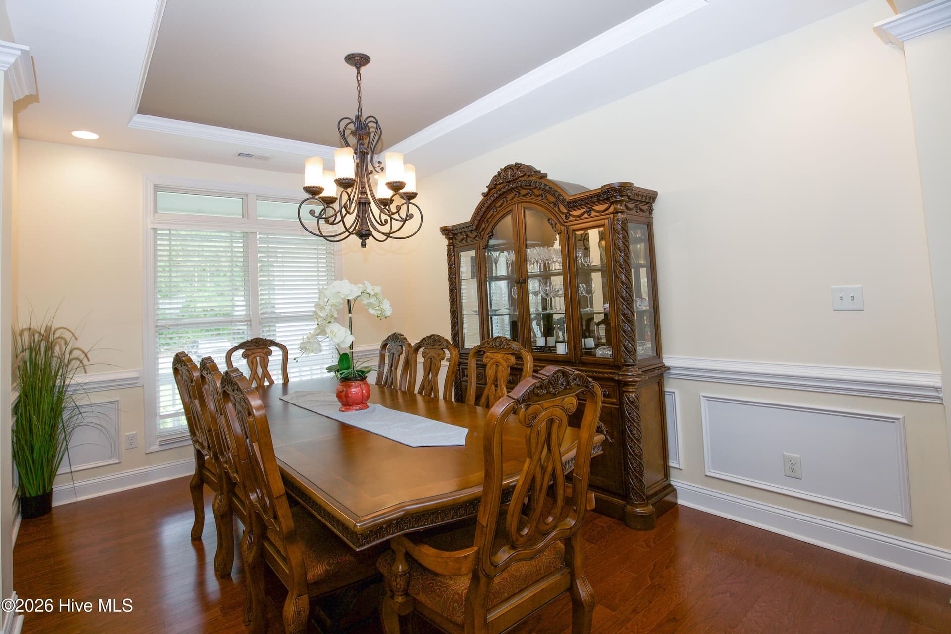 Dining room with a tray ceiling, chandelier, and wainscoting. - 899 Seagull Drive, Vass, NC 28394