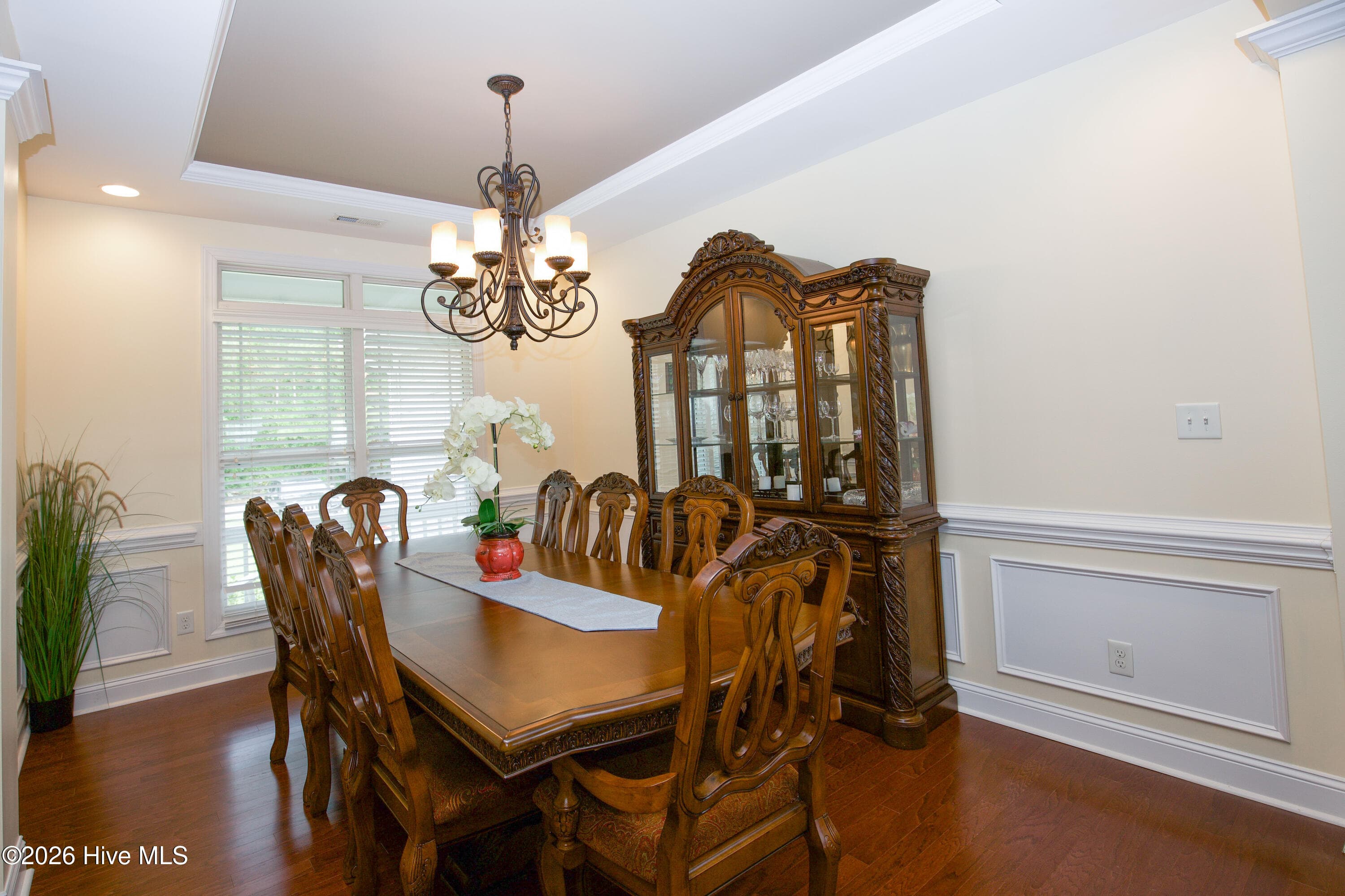 Dining room with a tray ceiling, chandelier, and wainscoting. - 899 Seagull Drive, Vass, NC 28394, Vass