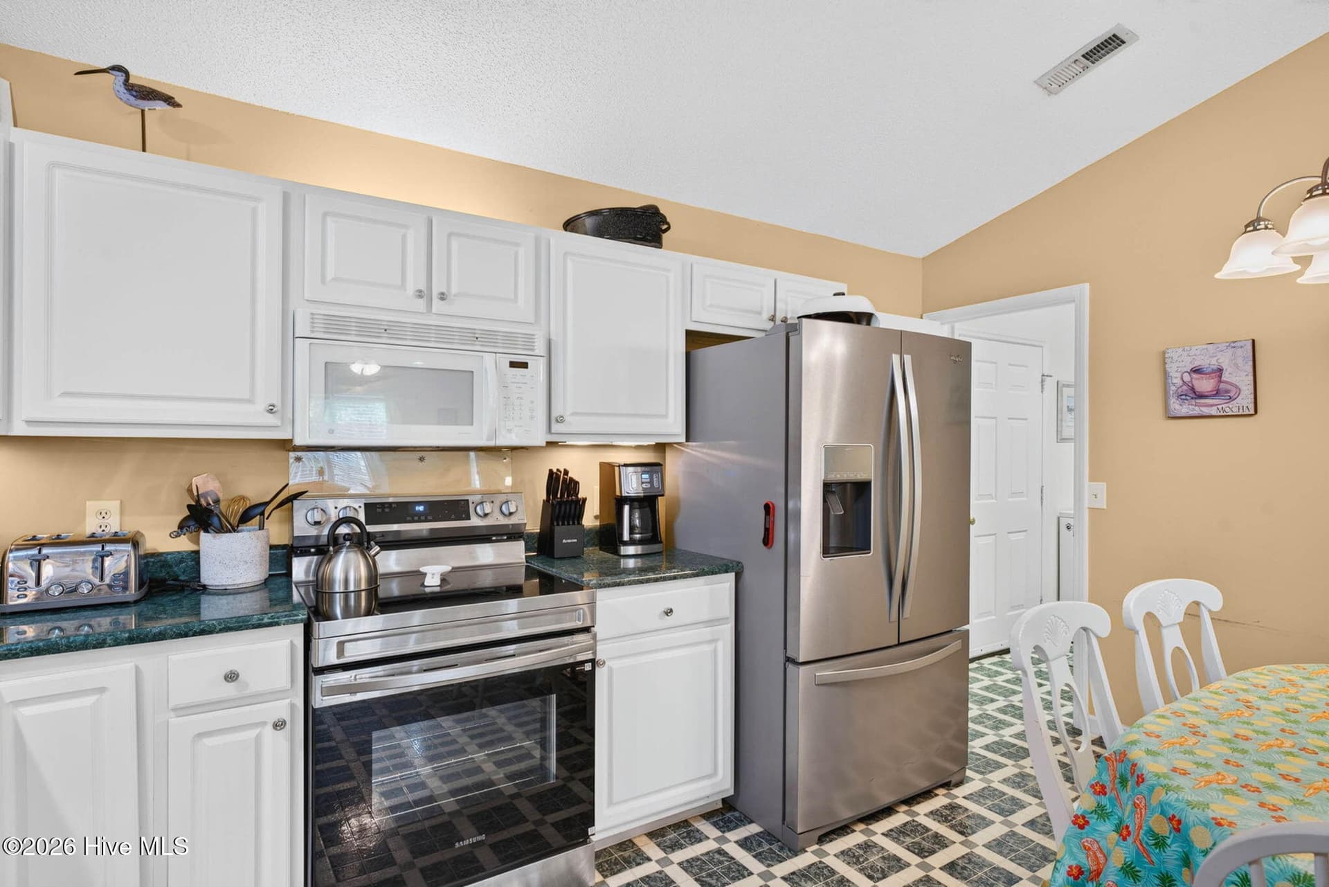 Stainless steel appliances and ample cabinetry provide a practical, well-equipped kitchen near the coast. - 1650 Frink Street SW, Ocean Isle Beach, NC 28469