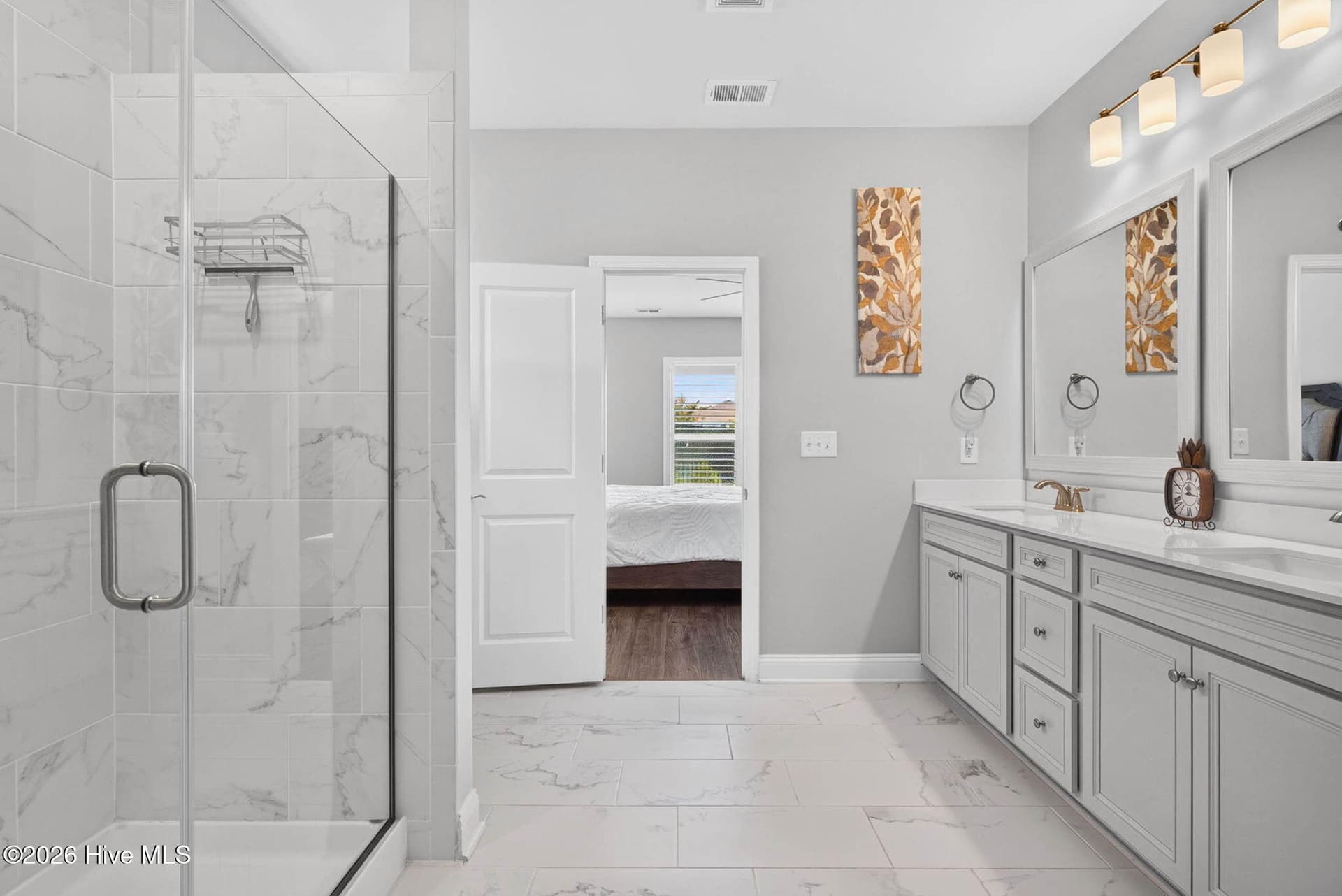 The primary bathroom offers dual vanities, a tiled walk-in shower, and a bright, polished design. - 139 Eagle Claw Drive, Calabash, NC 28467