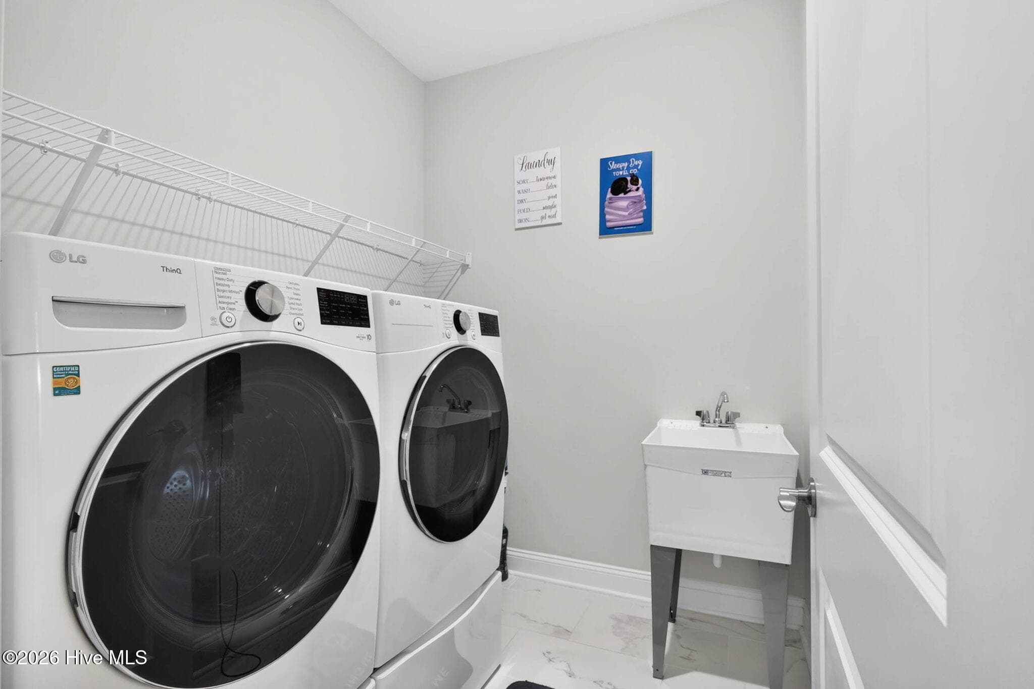 A dedicated laundry room offers cabinetry, a utility sink, and space for a full-size washer and dryer. - 139 Eagle Claw Drive, Calabash, NC 28467