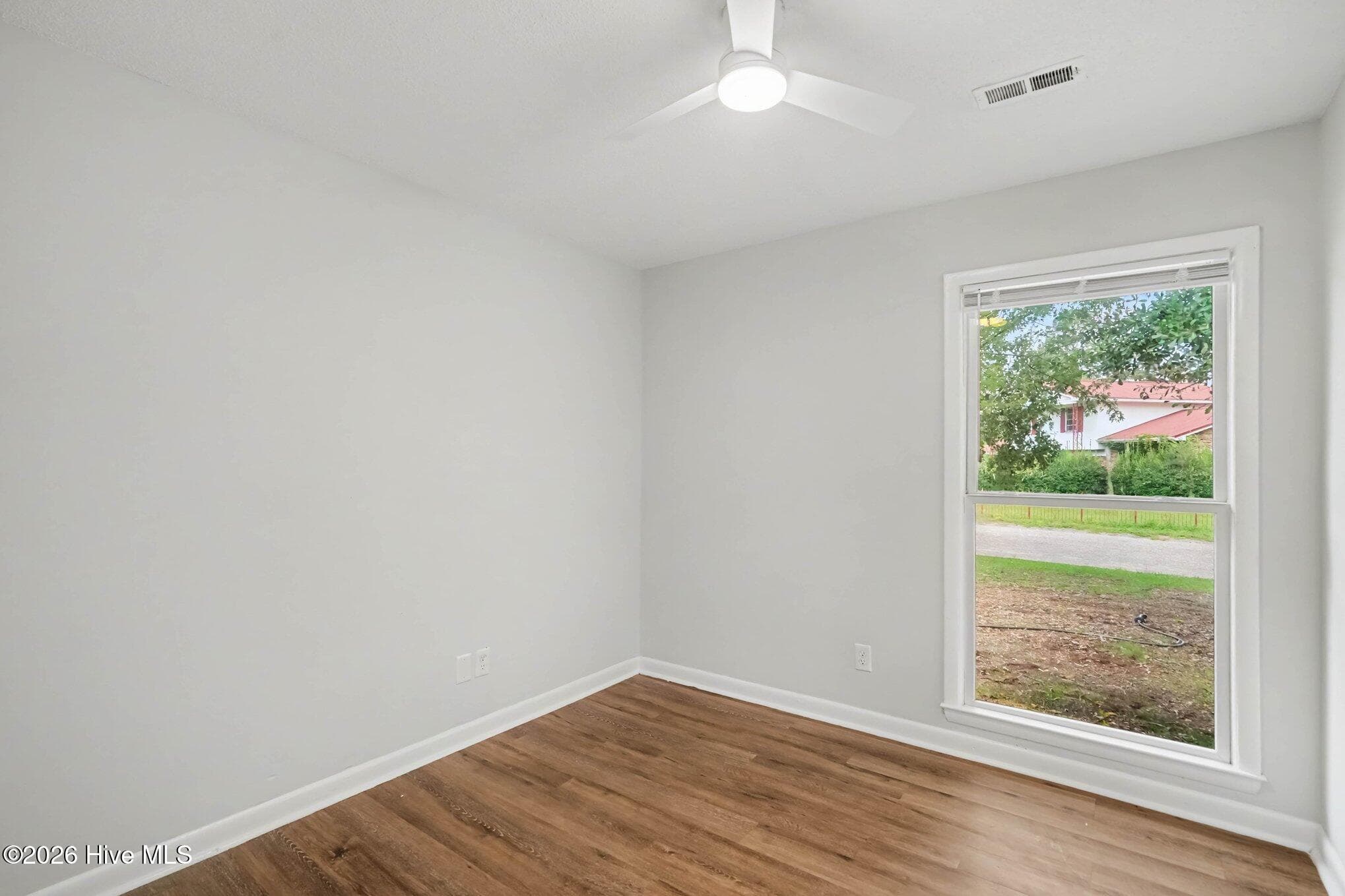 Cozy third bedroom highlighting a large bright window, modern ceiling fan, clean neutral paint, perfect for hobby space, guest room, or home office. - 108 Deerfield Drive, Spring Lake, NC 28390