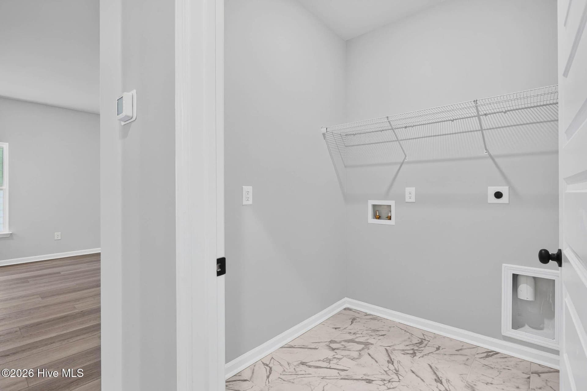 Convenient main-level laundry room with washer and dryer hookups and built-in storage shelving. - 3447 Sandhill Crane Drive SW, Ocean Isle Beach, NC 28469