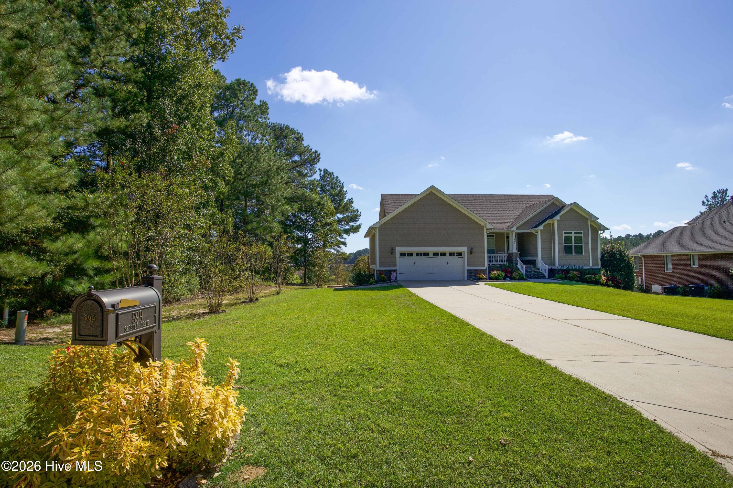 Approach from Seagull Drive, with a long driveway and front lawn leading to the home. - 899 Seagull Drive, Vass, NC 28394, Vass