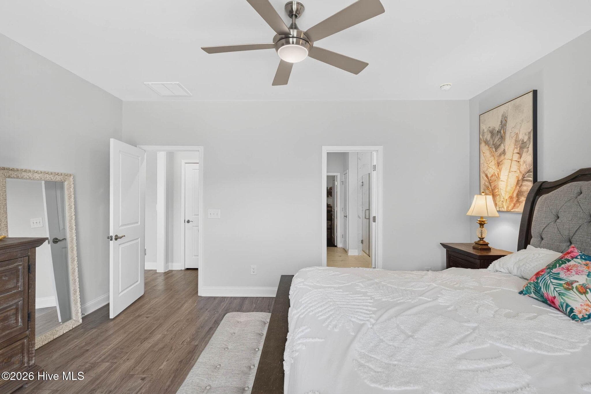 Another view of the primary bedroom highlights its generous size, luxury vinyl plank flooring, and private bathroom access. - 139 Eagle Claw Drive, Calabash, NC 28467