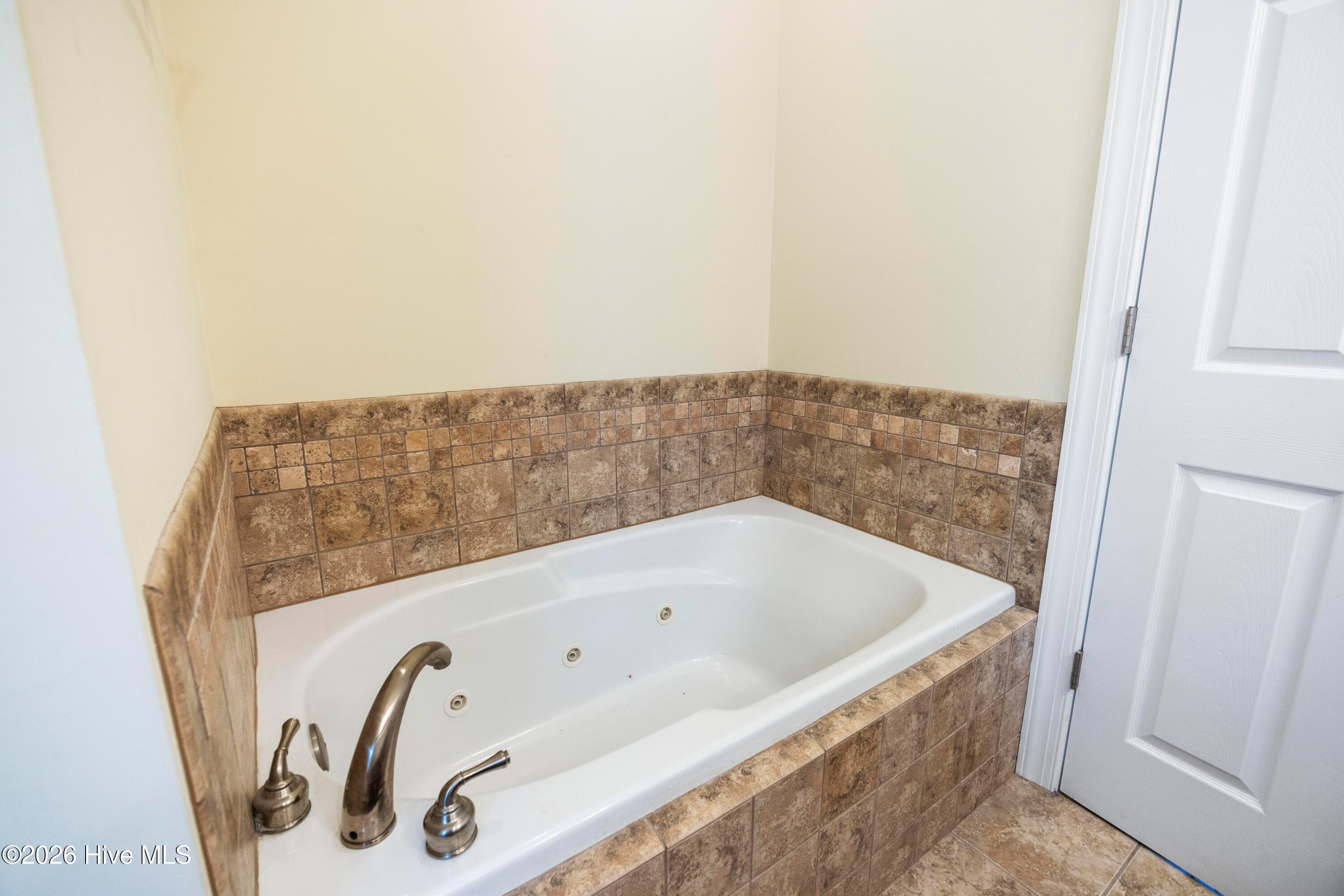 PRIMARY BEDROOM with En Suite Bathroom features jetted Soaking Tub - 225 NE 39th Street, Oak Island, NC 28465