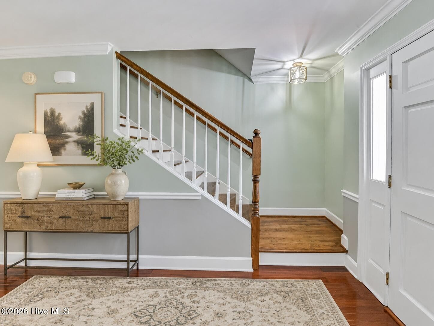 A welcoming entry sets the tone with soft color, hardwood floors, classic trim, and a beautifully styled staircase. - 16 Rapids Court, North Augusta, SC 29841
