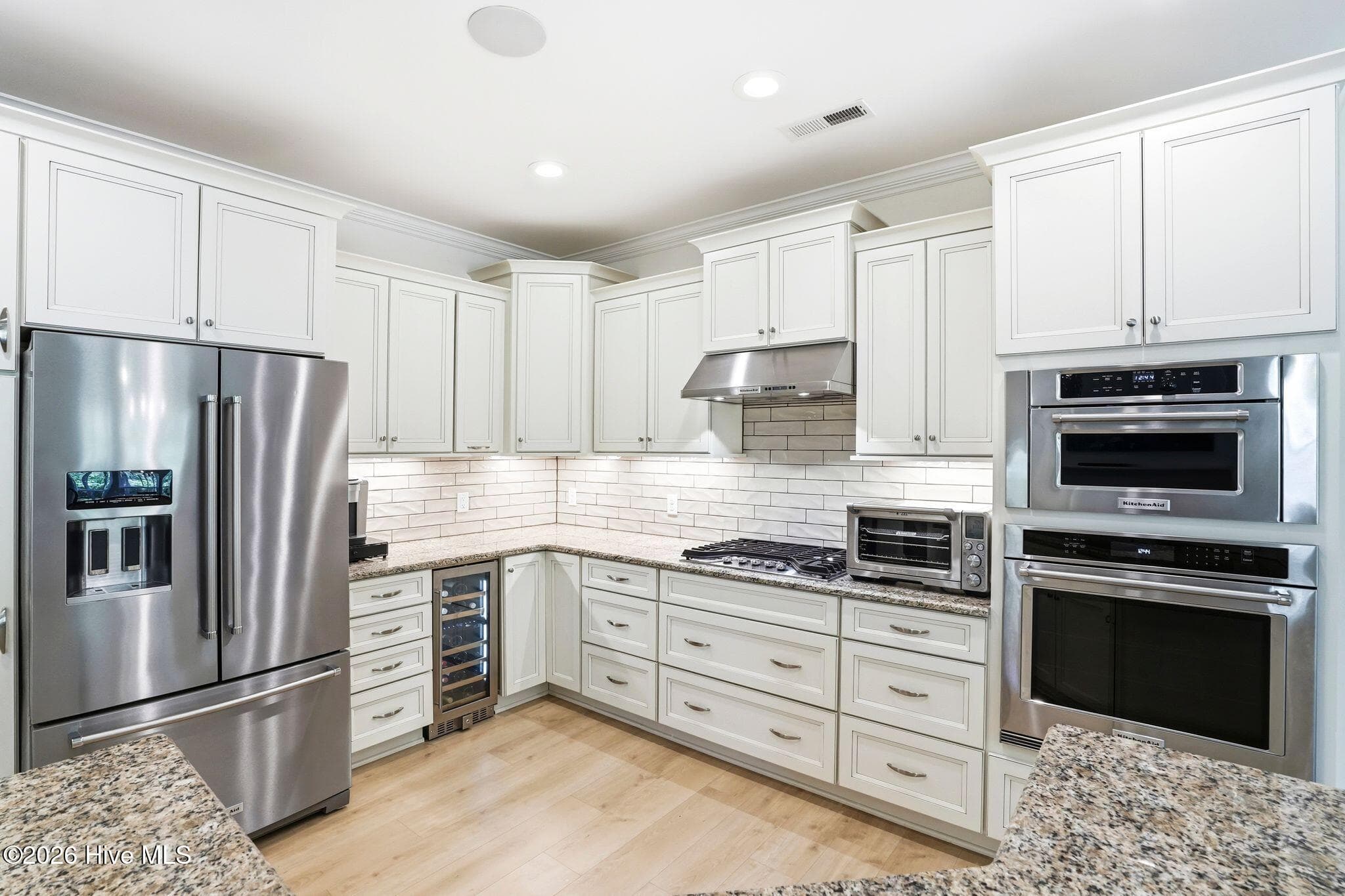 Kitchen - beverage cooler, gas cooktop, built-in oven, garbage disposal, dishwasher, and refrigerator. - 3710 Friendly Orange Court NE, Leland, NC 28451
