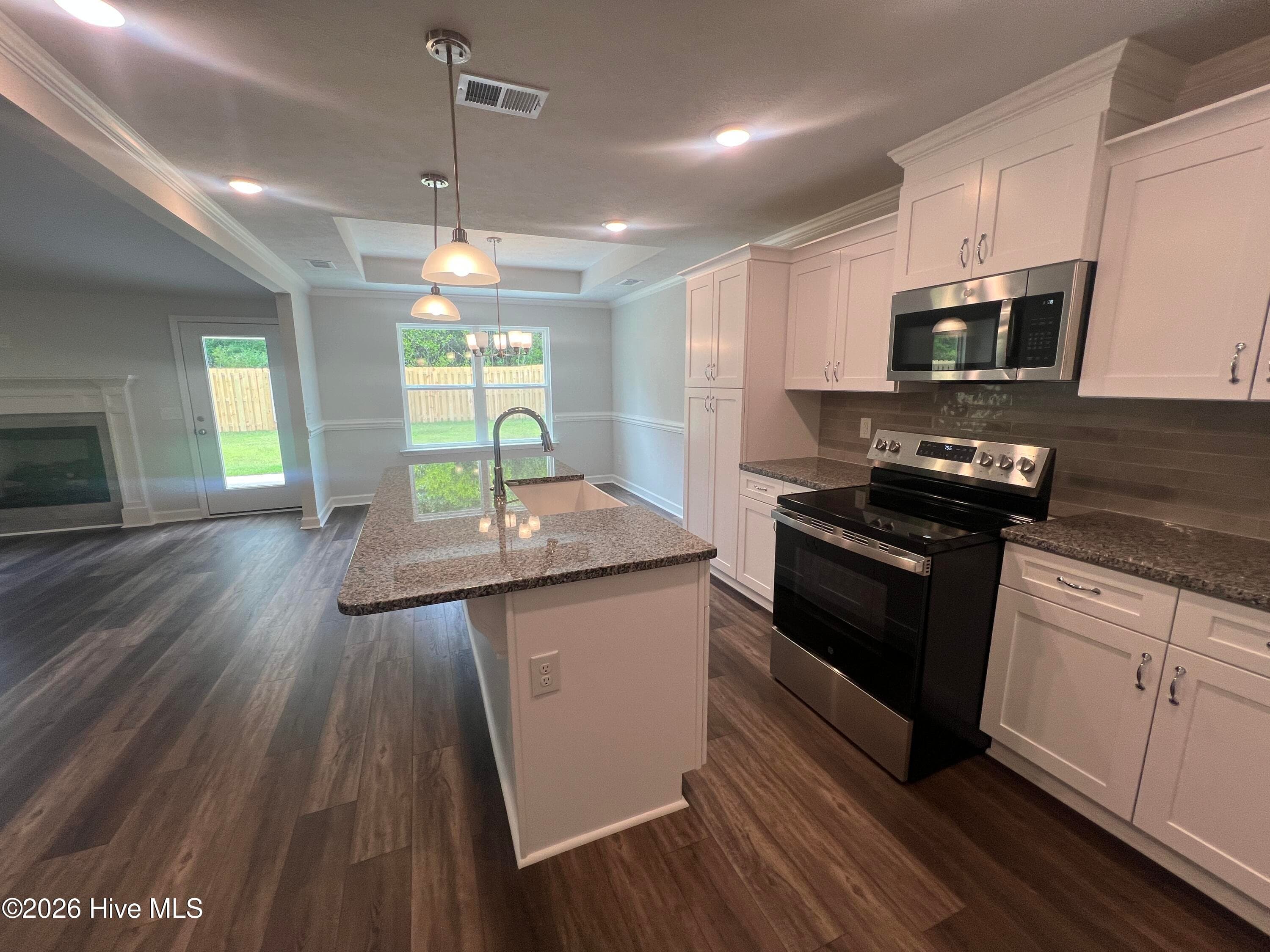 Beautiful granite counter tops with full tile backsplash, soft close cabinetry, and stainless steel appliances. - 8887 Snelling Drive, Aiken, SC 29803