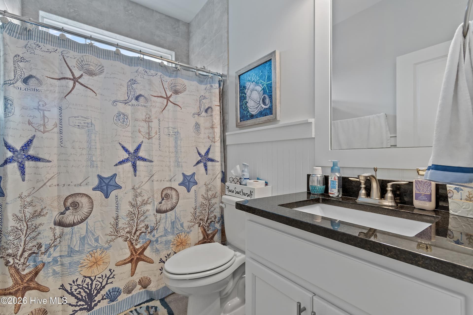 Bathroom on first floor to be shared by bedroom #1 and bedroom #2. Granite countertop, beadboard accents. - 6358 Bryson Drive SW, Ocean Isle Beach, NC 28469