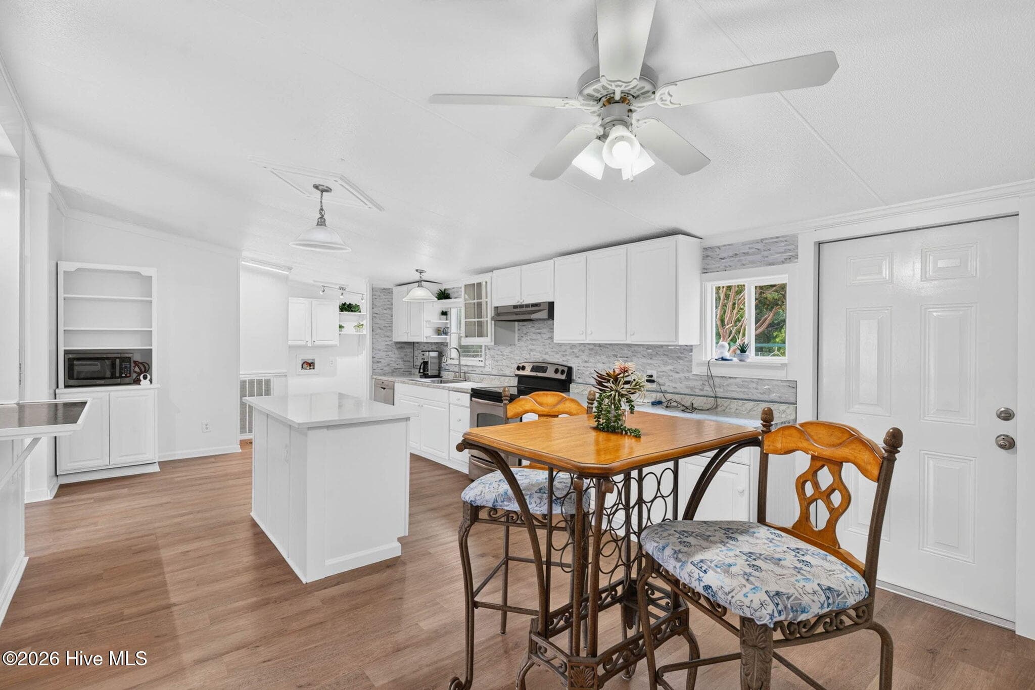 Updated kitchen featuring crisp white cabinetry, a large breakfast bar, generous counter space, and an open design overlooking the main living areas. - 1199 Zack Street SE, Bolivia, NC 28422