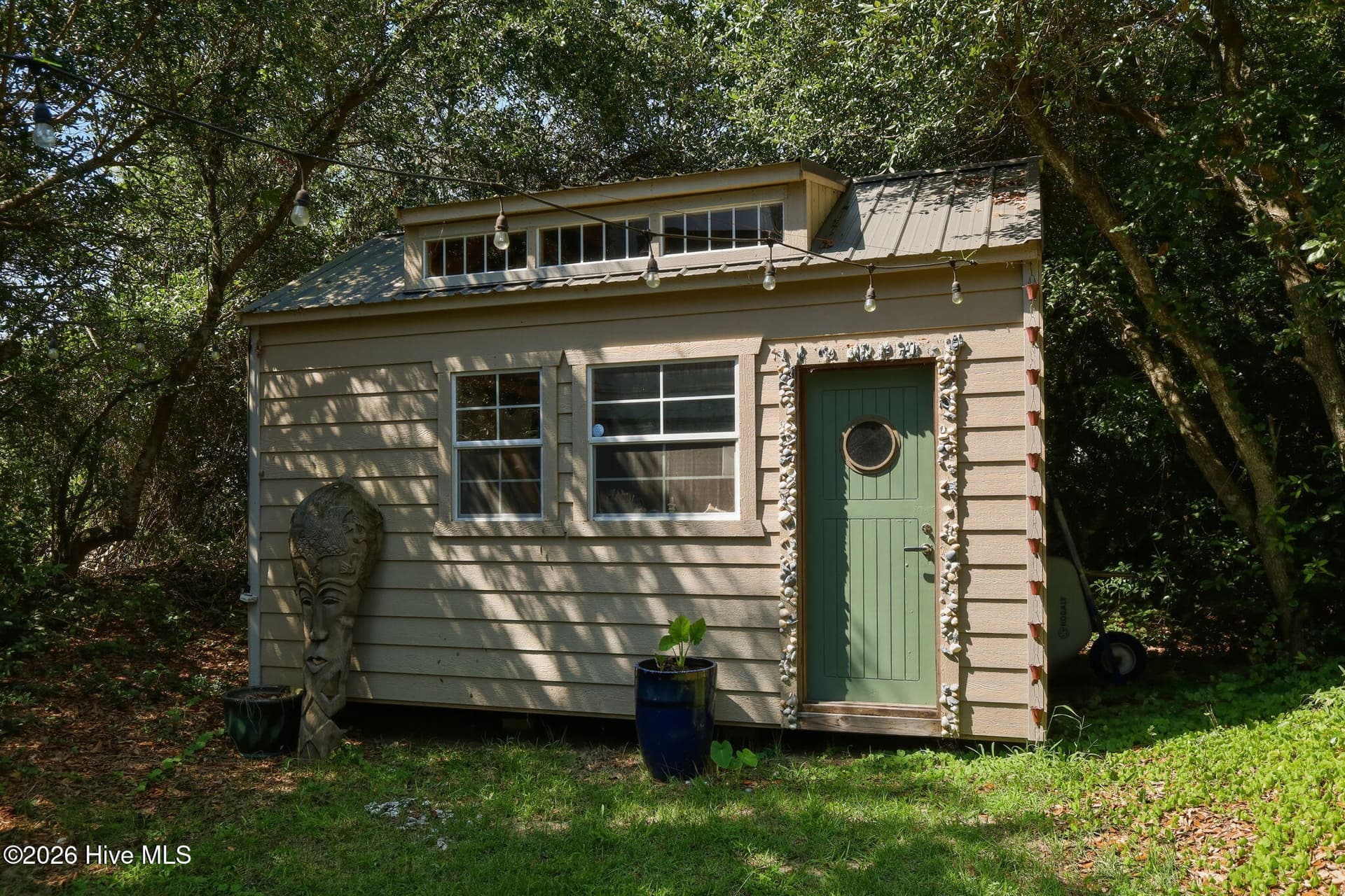 Charming backyard she shed adds a unique bonus space with endless possibilities for hobbies, crafts, or a personal retreat. - 103 Georgia Street, Emerald Isle, NC 28594