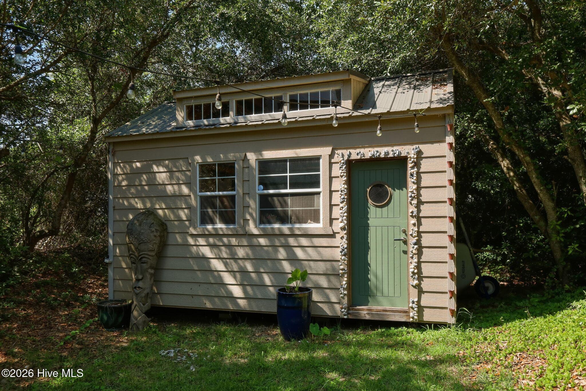 Charming backyard she shed adds a unique bonus space with endless possibilities for hobbies, crafts, or a personal retreat. - 103 Georgia Street, Emerald Isle, NC 28594