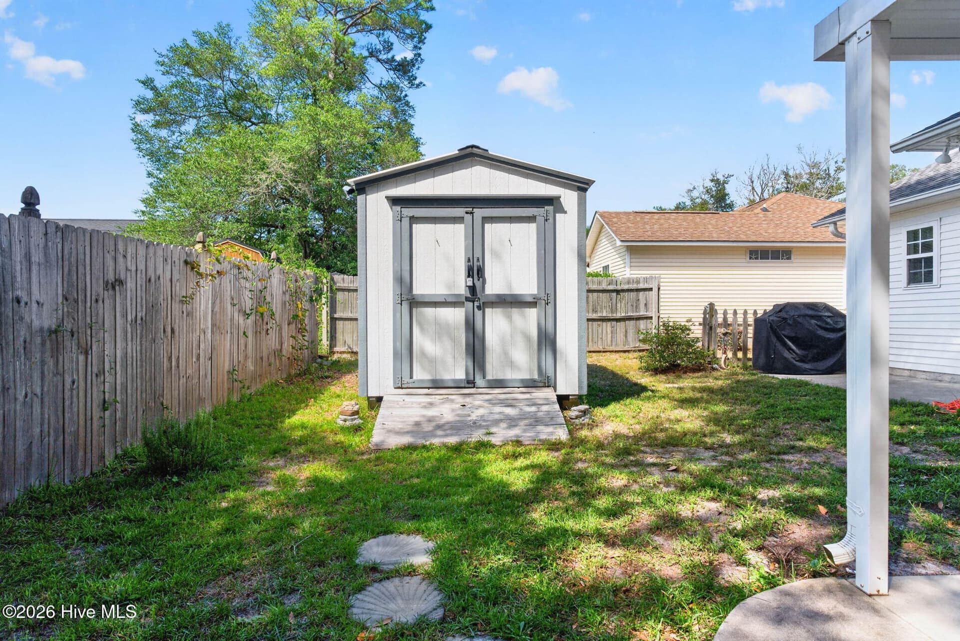 Detached backyard storage shed provides dedicated space for beach chairs, bicycles, yard equipment, and coastal gear. - 1650 Frink Street SW, Ocean Isle Beach, NC 28469