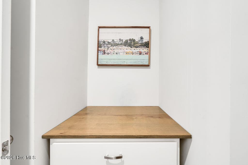 This pass-through laundry room features a built-in folding station and connects one of the owner's suite walk-in closets to the entryway. - 142 Rice Marsh Way, Wilmington, NC 28412