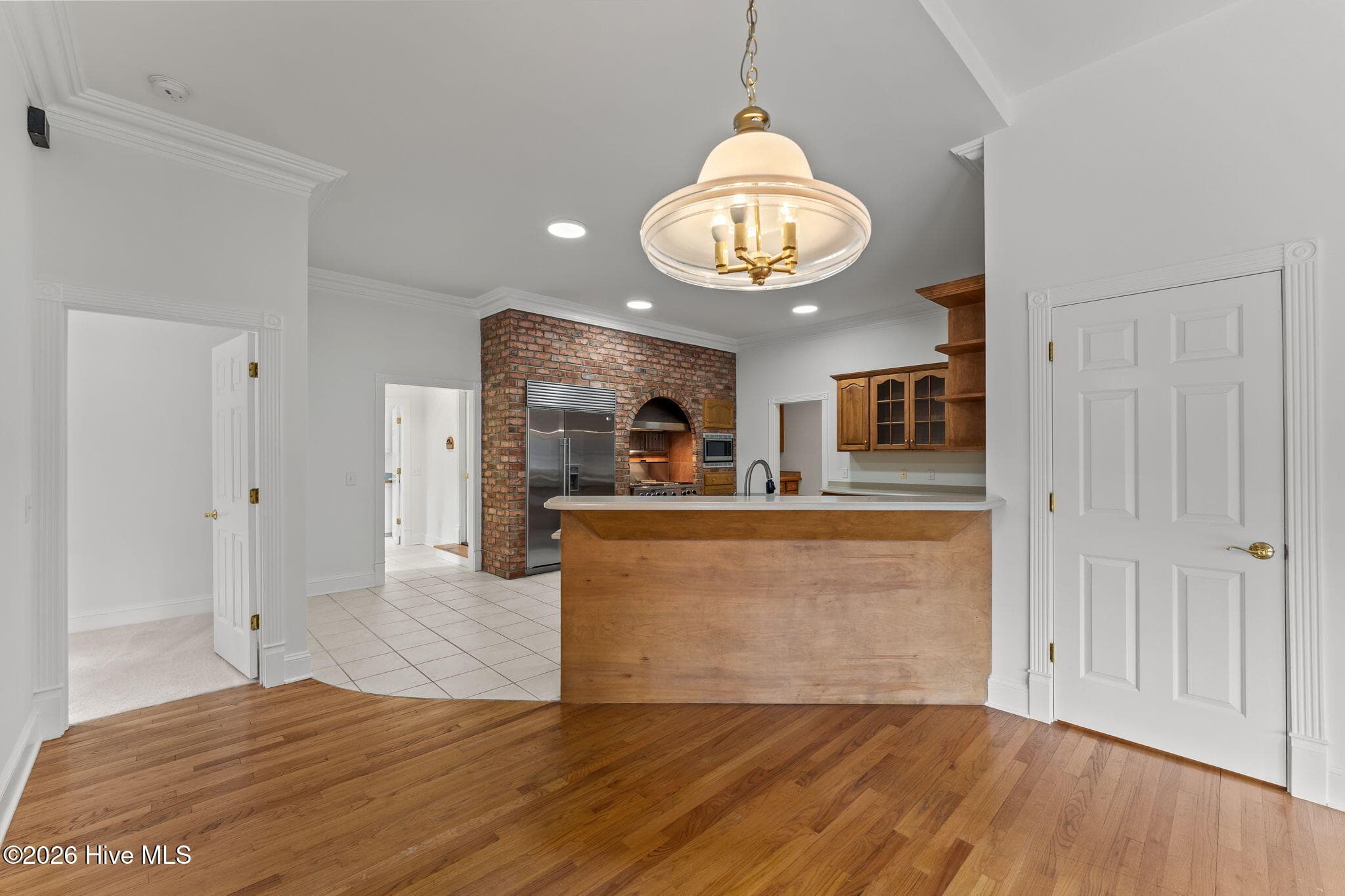 View of the kitchen with the laundry room and second half bathroom down the hallway to the left. Garage entrance is in this hallway too. Primary bathroom is doorway off to the left. - 22 Lochmere Drive, Pinehurst, NC 28374