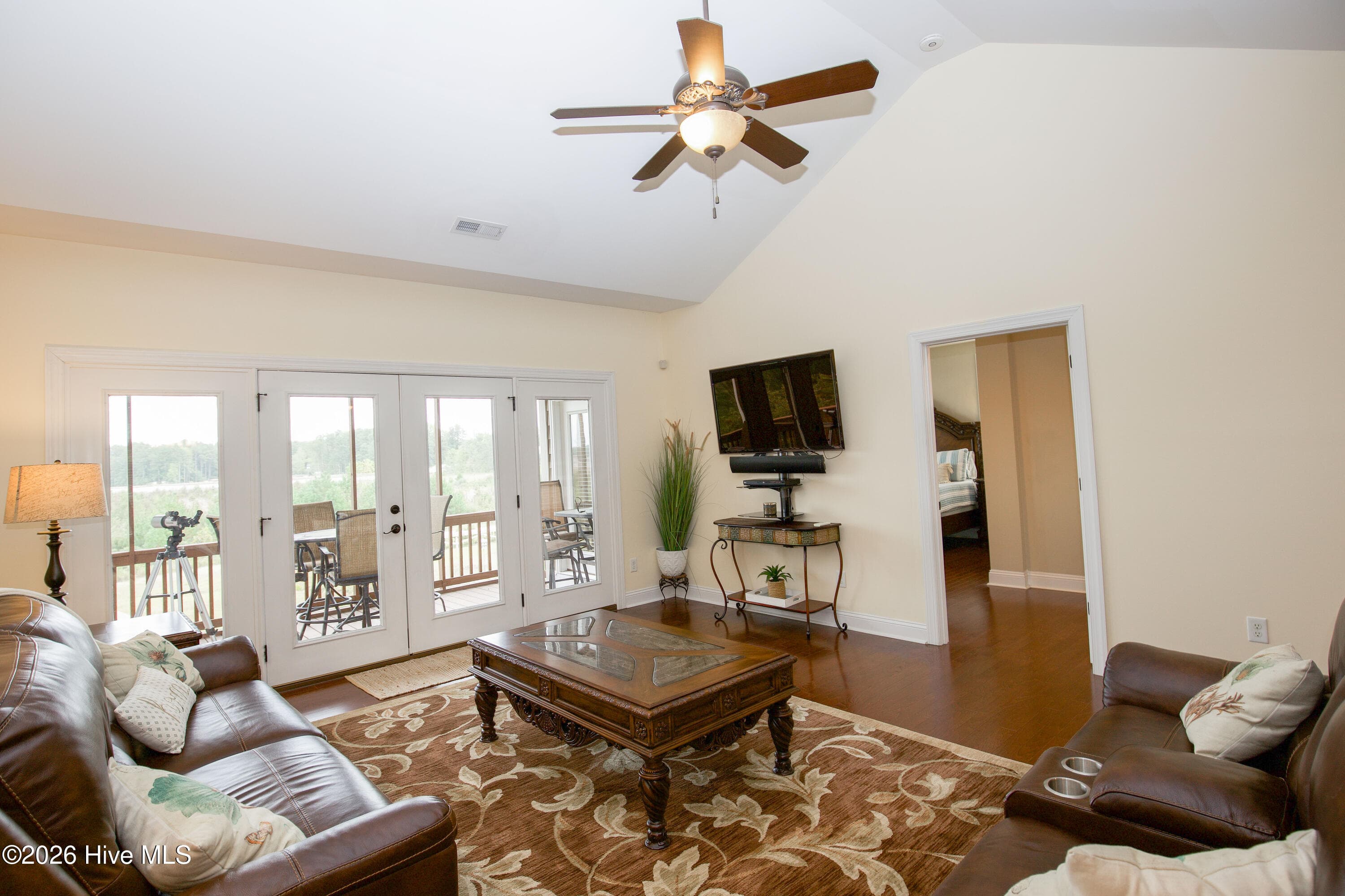 Vaulted main-level living room with French doors to the screened porch. - 899 Seagull Drive, Vass, NC 28394, Vass