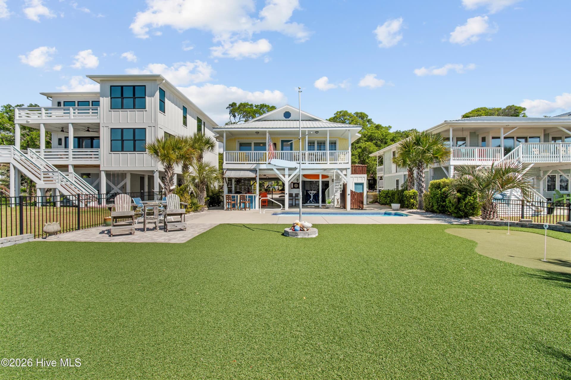Expansive backyard with pool, artificial turf, putting green and tons of coastal landscaping. - 2024 Camelot Drive SW, Ocean Isle Beach, NC 28469