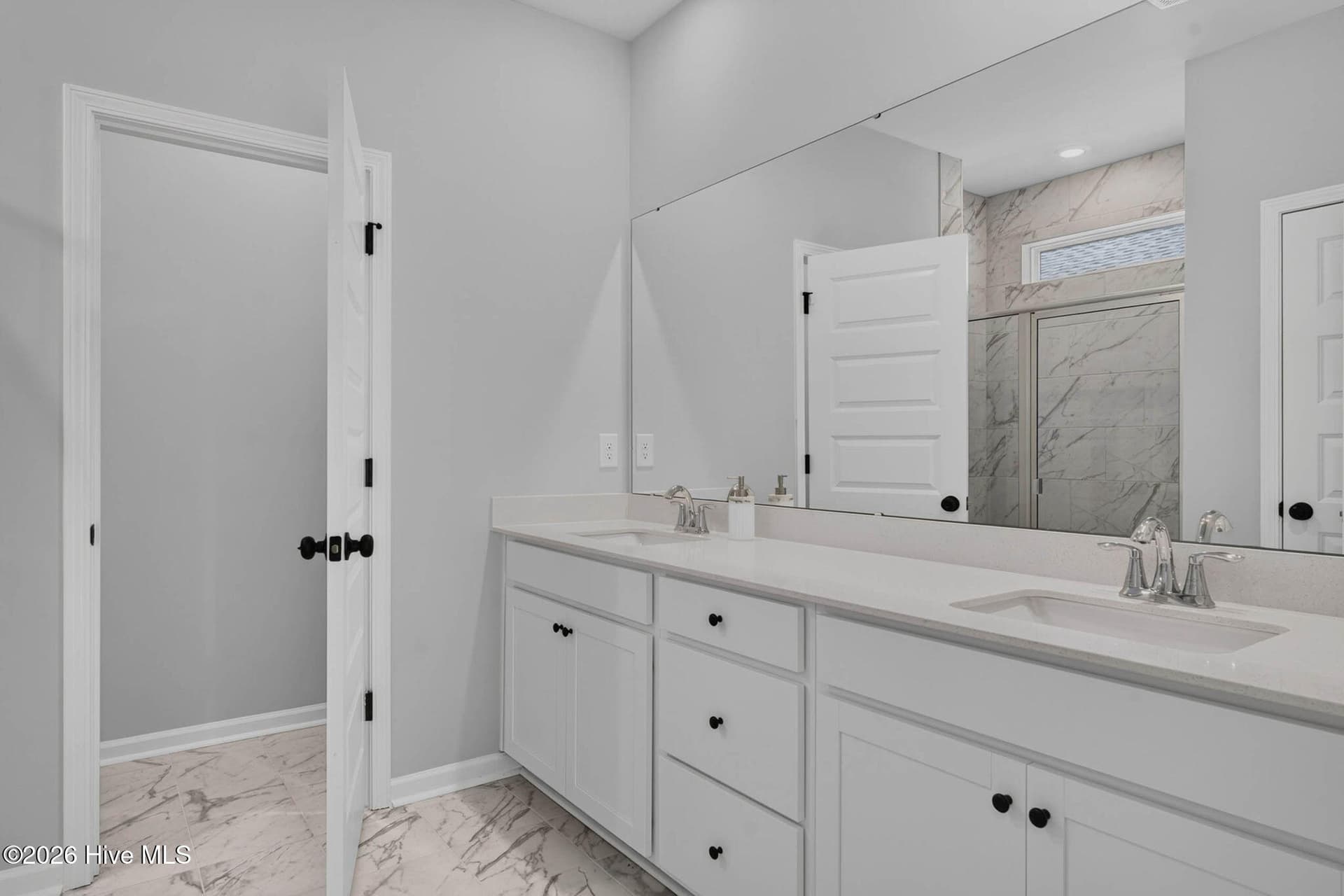 Primary ensuite bathroom featuring a dual-sink vanity, generous countertop space, and modern finishes. - 3447 Sandhill Crane Drive SW, Ocean Isle Beach, NC 28469