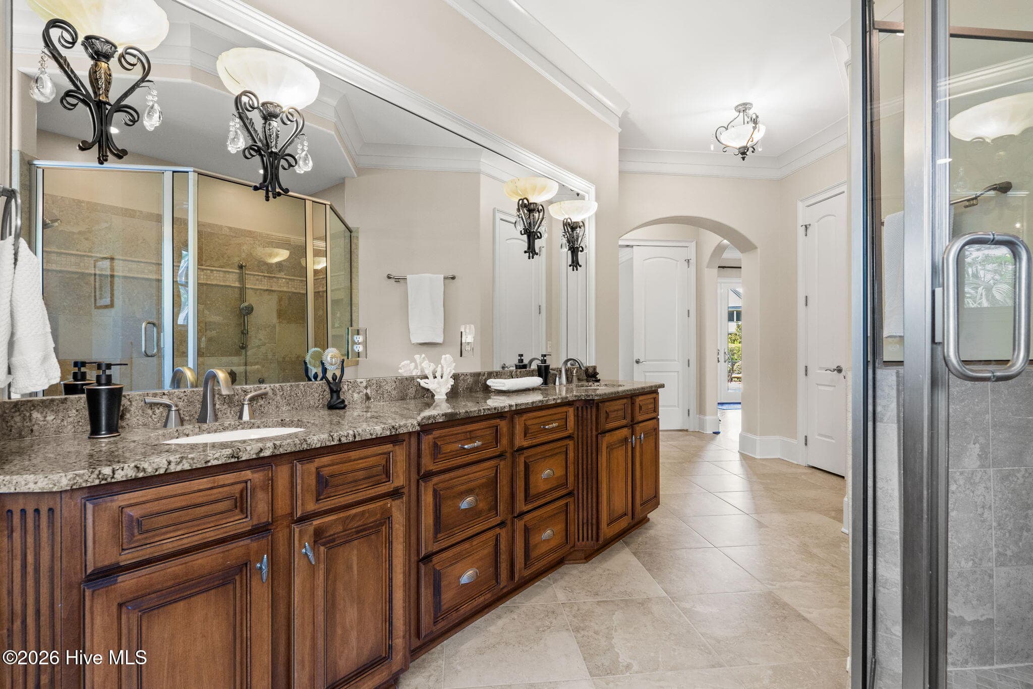 Primary bath has double sinks, warm tone cabinetry and granite countertops. - 3858 Ridge Crest Drive, Southport, NC 28461