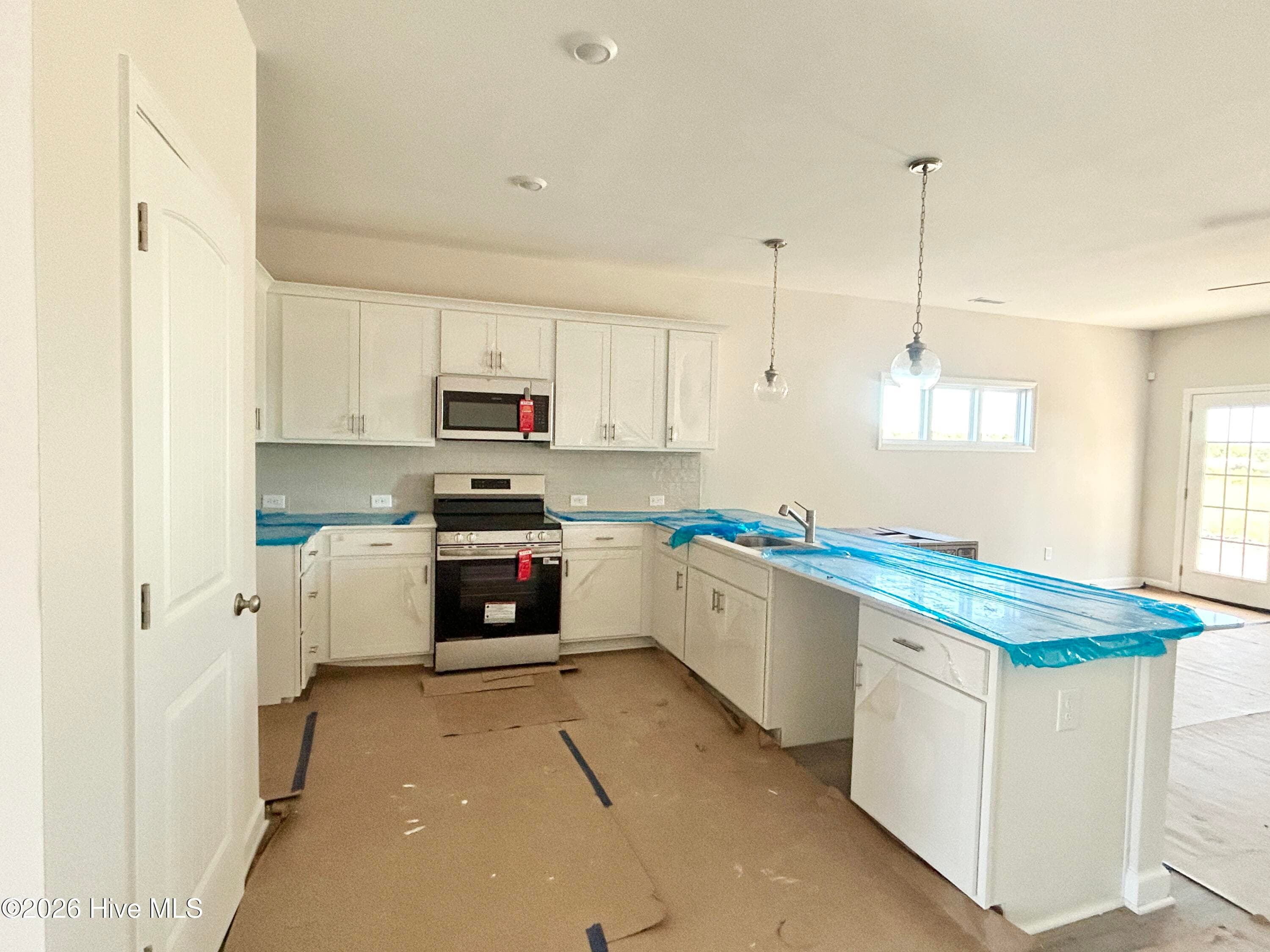 Elegant Kitchen includes Quartz Countertops, Stainless Appliances, Tile Backsplash, and Beautiful Lighting fixtures. - 4192 Workman Loop 90, Leland, NC 28451