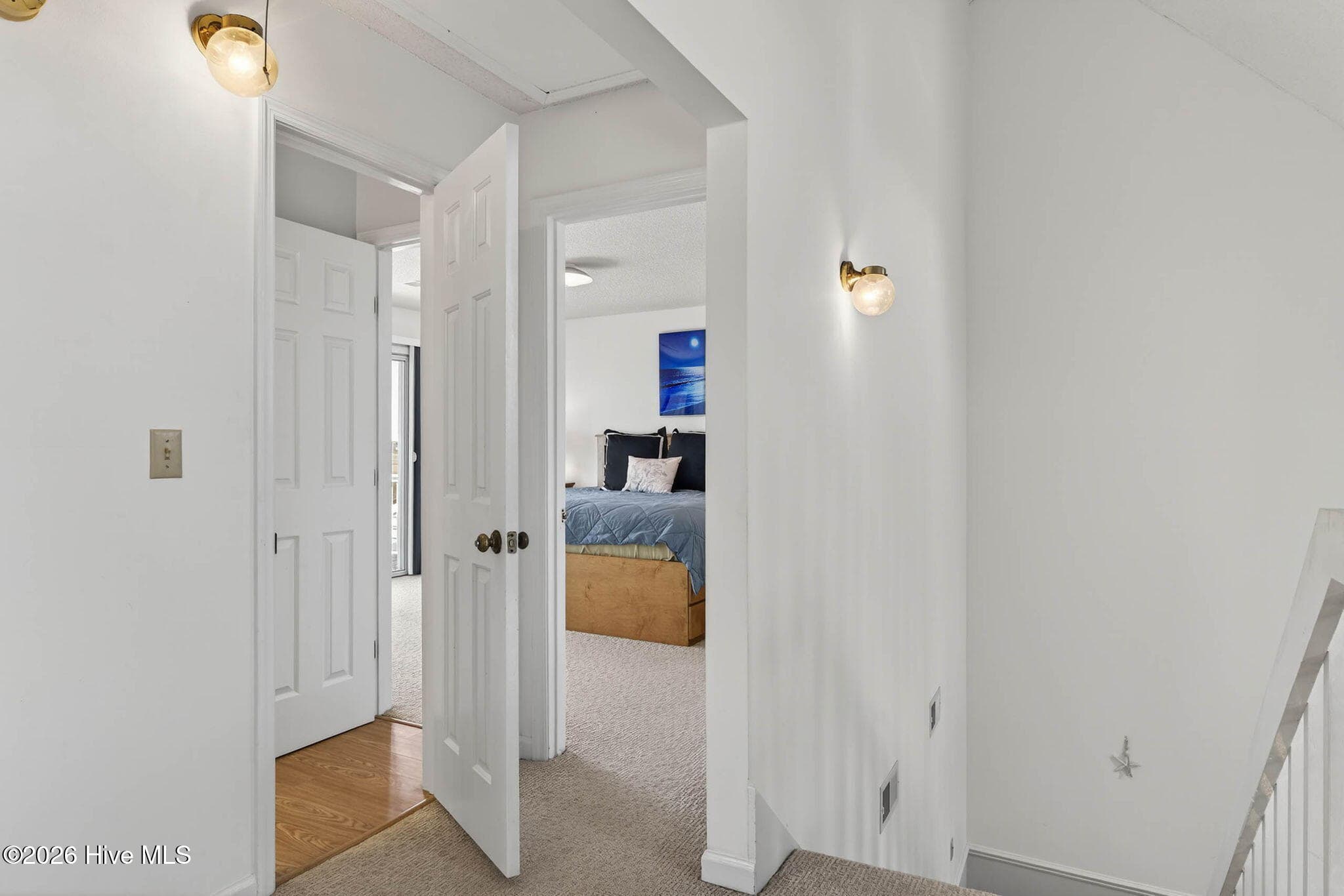 Clean and bright hallway connecting bedrooms and flex space upstairs. - 1206 N Shore Drive W, Sunset Beach, NC 28468