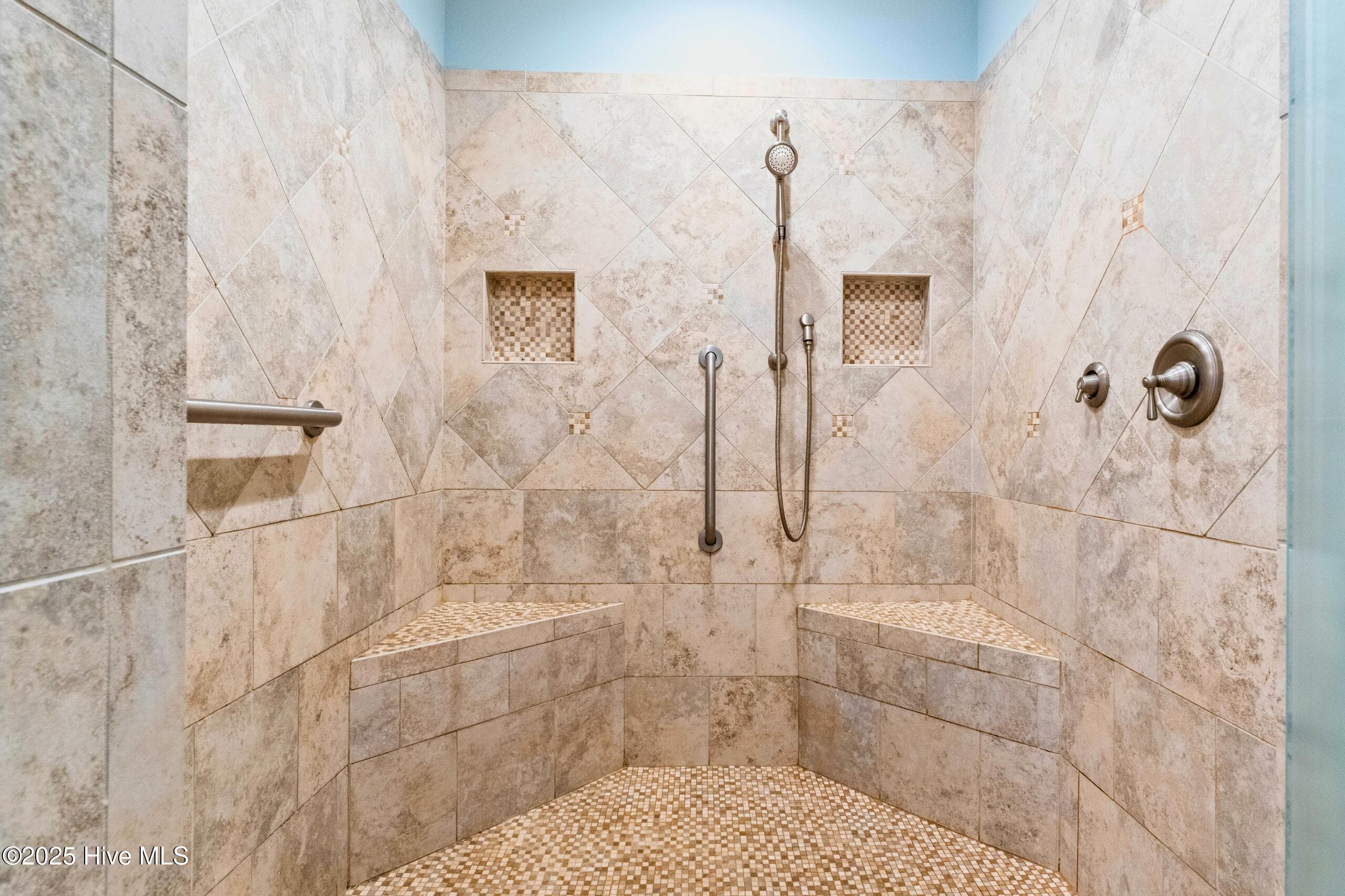 Luxurious primary en-suite bath featuring a custom tiled walk-in shower with dual shower heads and premium finishes. - 9100 Fountain Street SW, Calabash, NC 28467