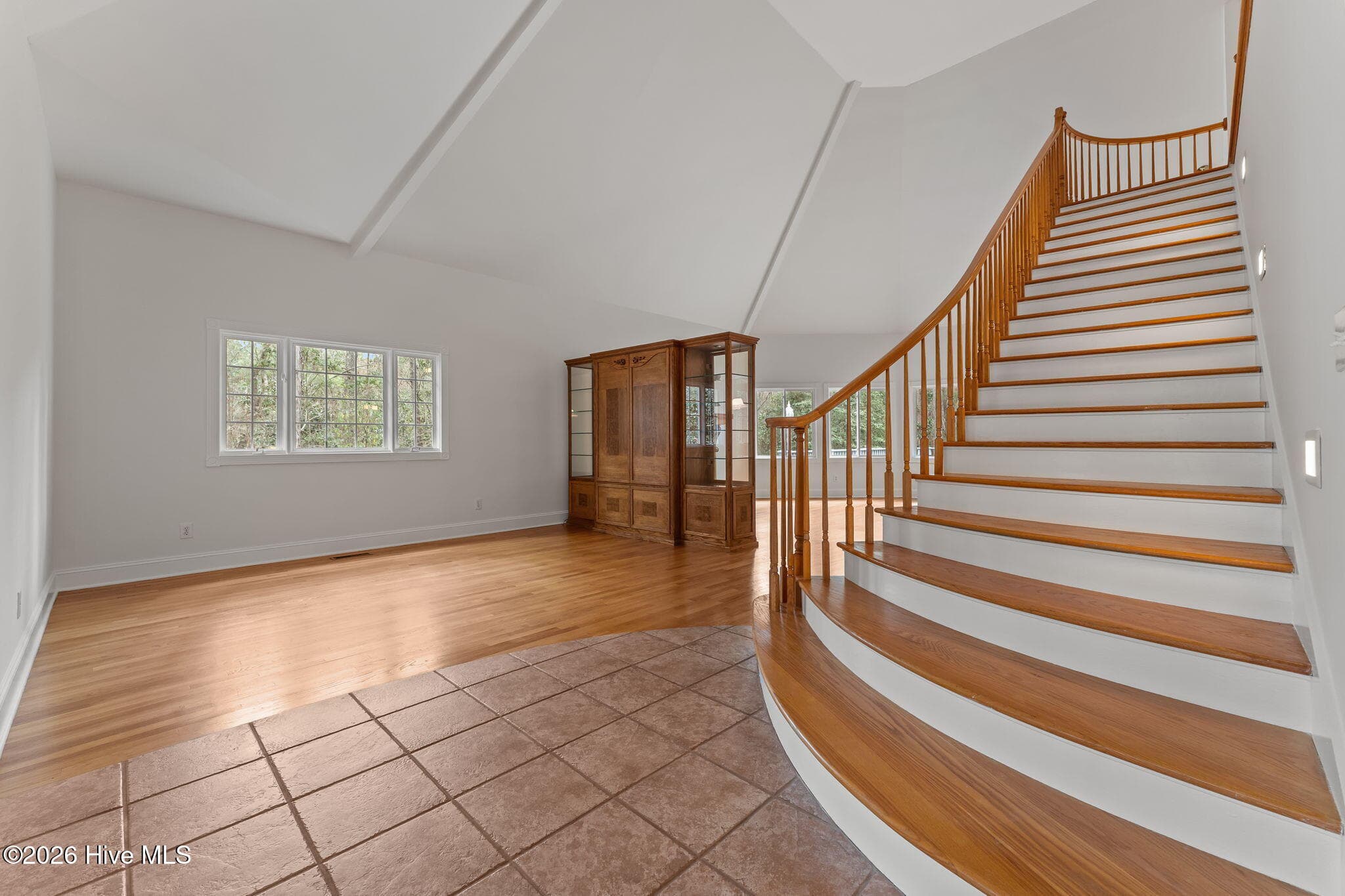 View of the great room which is divide by a grand entertainment center. Staircase leads to two bedrooms and a bathroom with separate vanities, Jack and Jill set up. Also lots of attic area for storage or potential for a bonus/theater room. - 22 Lochmere Drive, Pinehurst, NC 28374