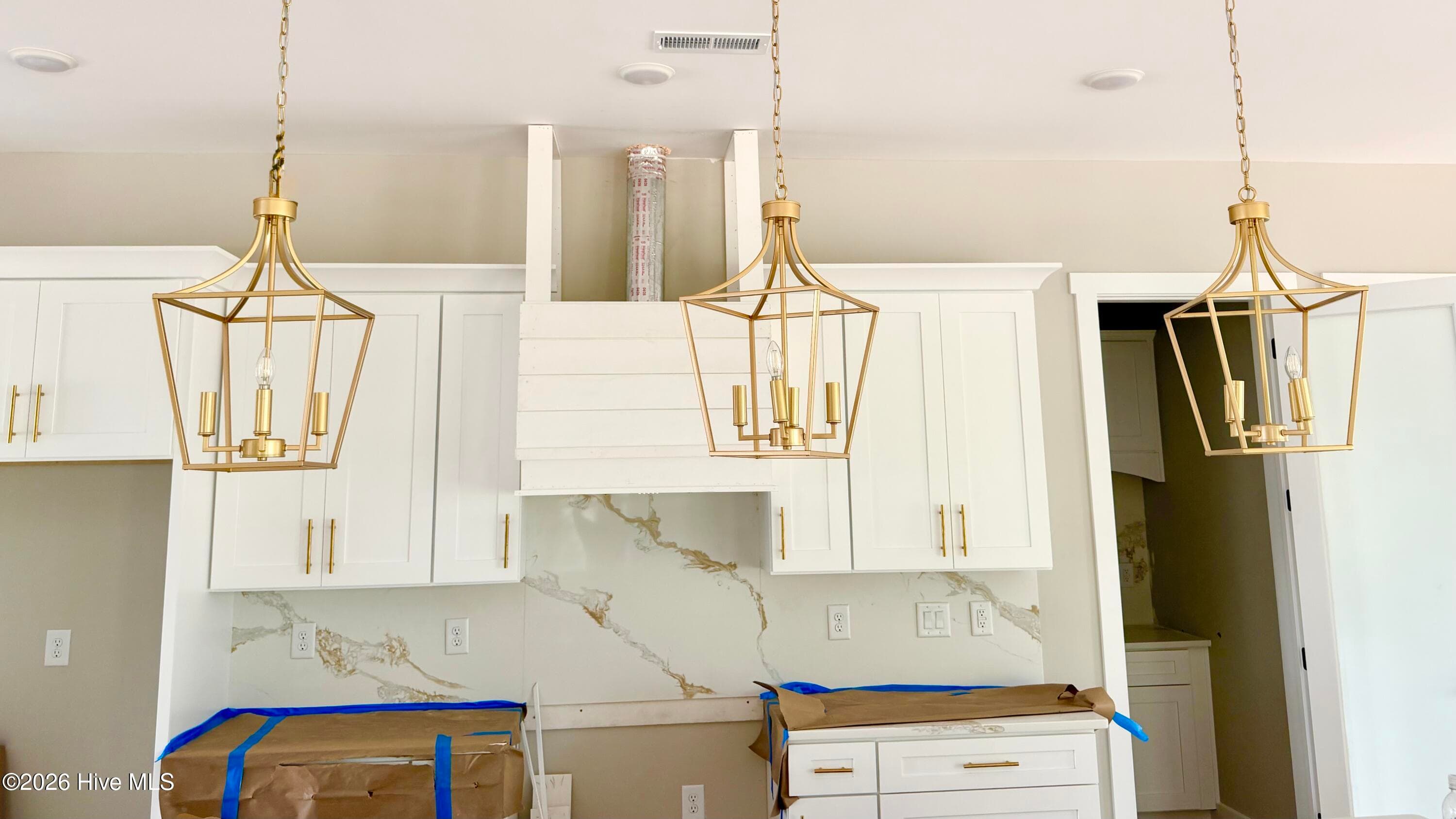 Custom kitchen lighting over island, custom counters, backsplash and cabinet pulls, under construction. Appliances to be installed. - 550 Glenburnie Street NW, Calabash, NC 28467