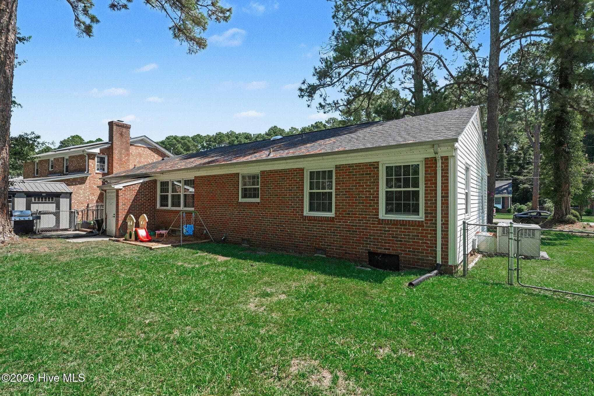 Rear view of home with attached utility storage and detached storage/shop. - 1017 S Claiborne Street, Goldsboro, NC 27530