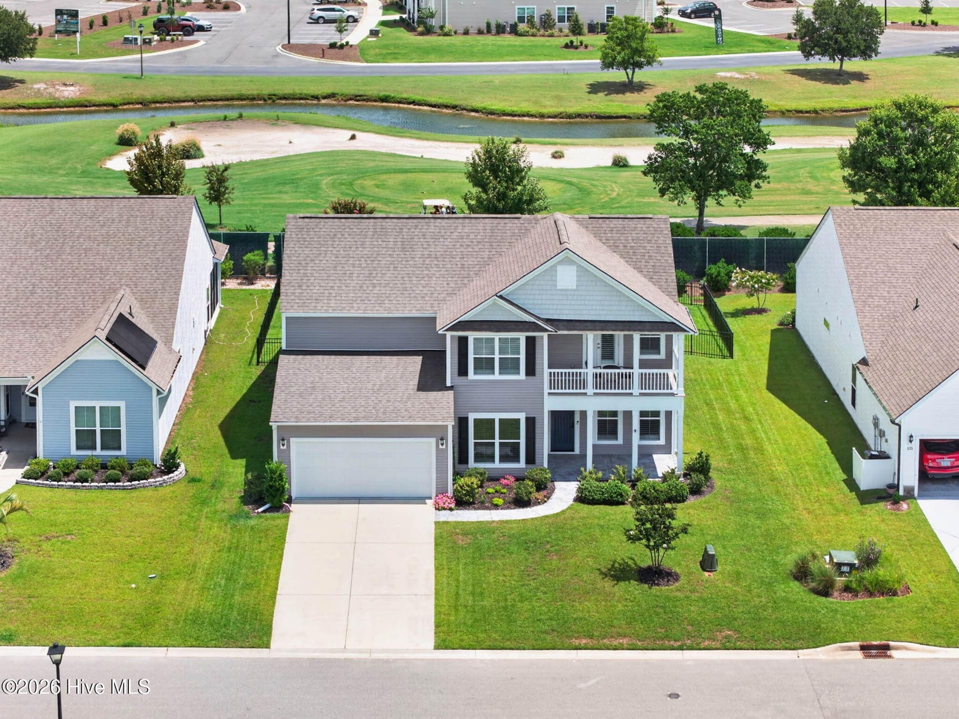 This aerial view showcases the home’s attractive exterior, landscaped front yard, and golf-course location. - 139 Eagle Claw Drive, Calabash, NC 28467