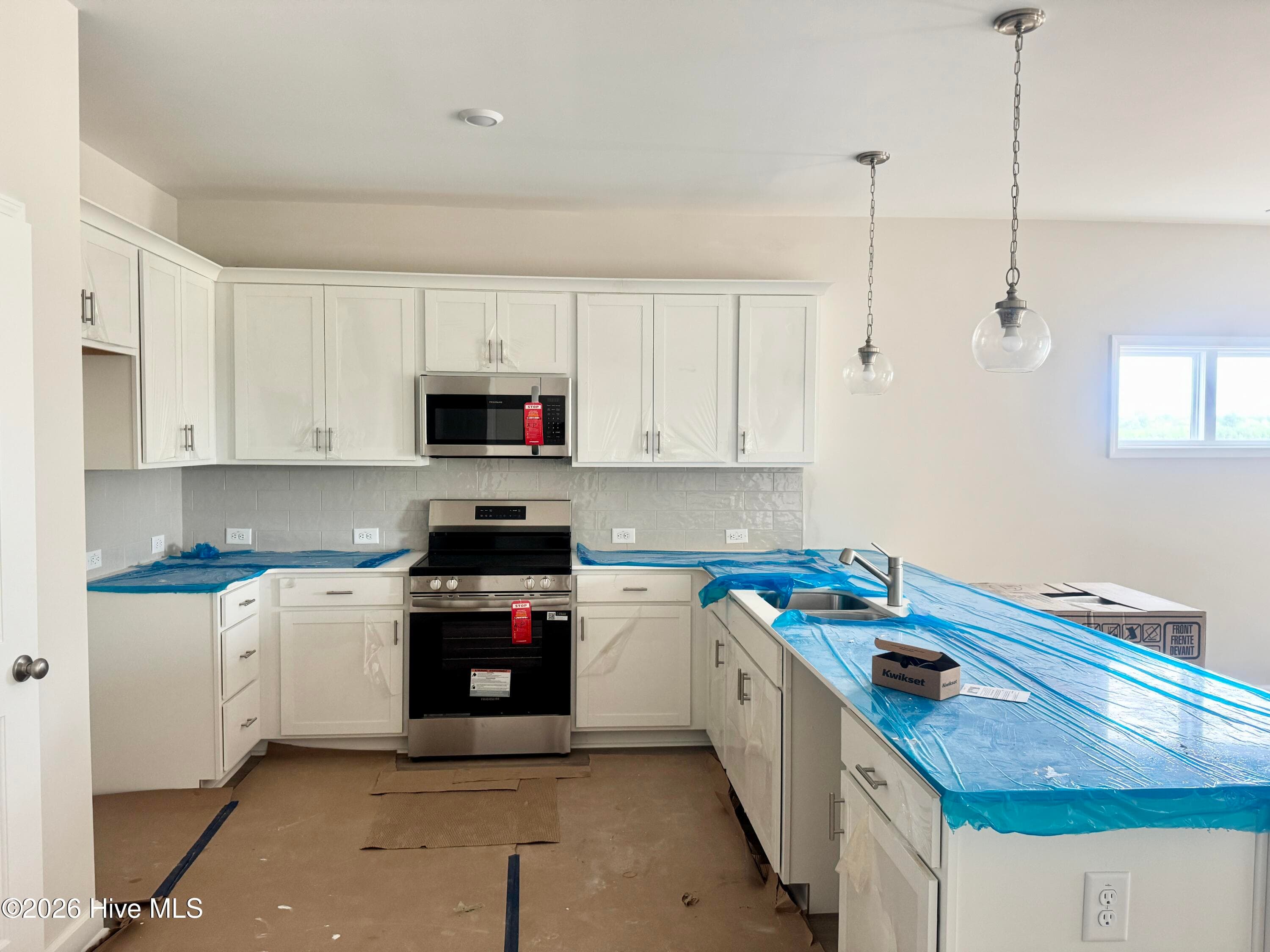 Elegant Kitchen includes Quartz Countertops, Stainless Appliances, Tile Backsplash, and Beautiful Lighting fixtures. - 4192 Workman Loop 90, Leland, NC 28451
