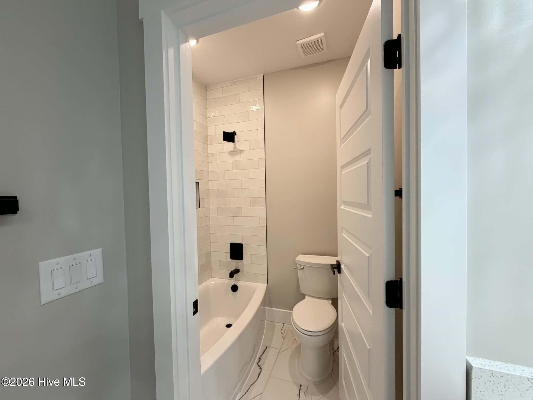 Guest bathroom upstairs, toilet and shower room. - 550 Glenburnie Street NW, Calabash, NC 28467