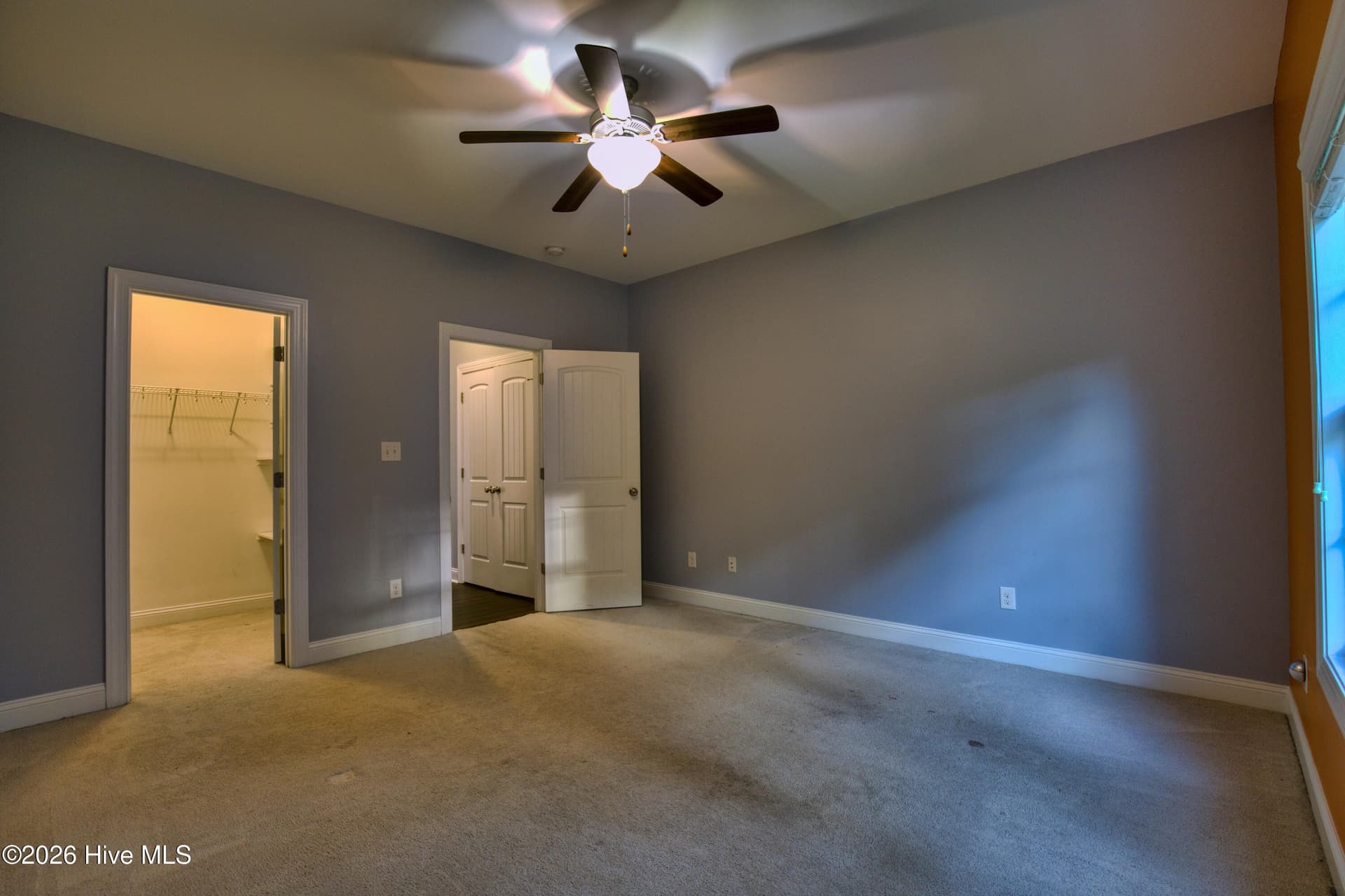 Bedroom two; view of walk in closet and door to hallway/linen closet. - 25 Aster Place, Hampstead, NC 28443