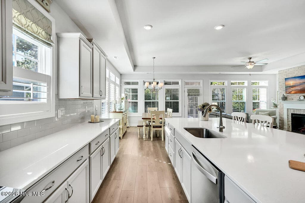 Chef-style kitchen island is the heart of this home and a natural gathering place. The kitchen also features upgraded premium staggered, color glazed cabinetry with dovetails, a single basin stainless sink, fully tiled backsplash throughout, upgraded stainless refrigerator and oven/range, upgraded granite countertops, brushed nickel lighting package, and custom plantation blinds. - 142 Rice Marsh Way, Wilmington, NC 28412