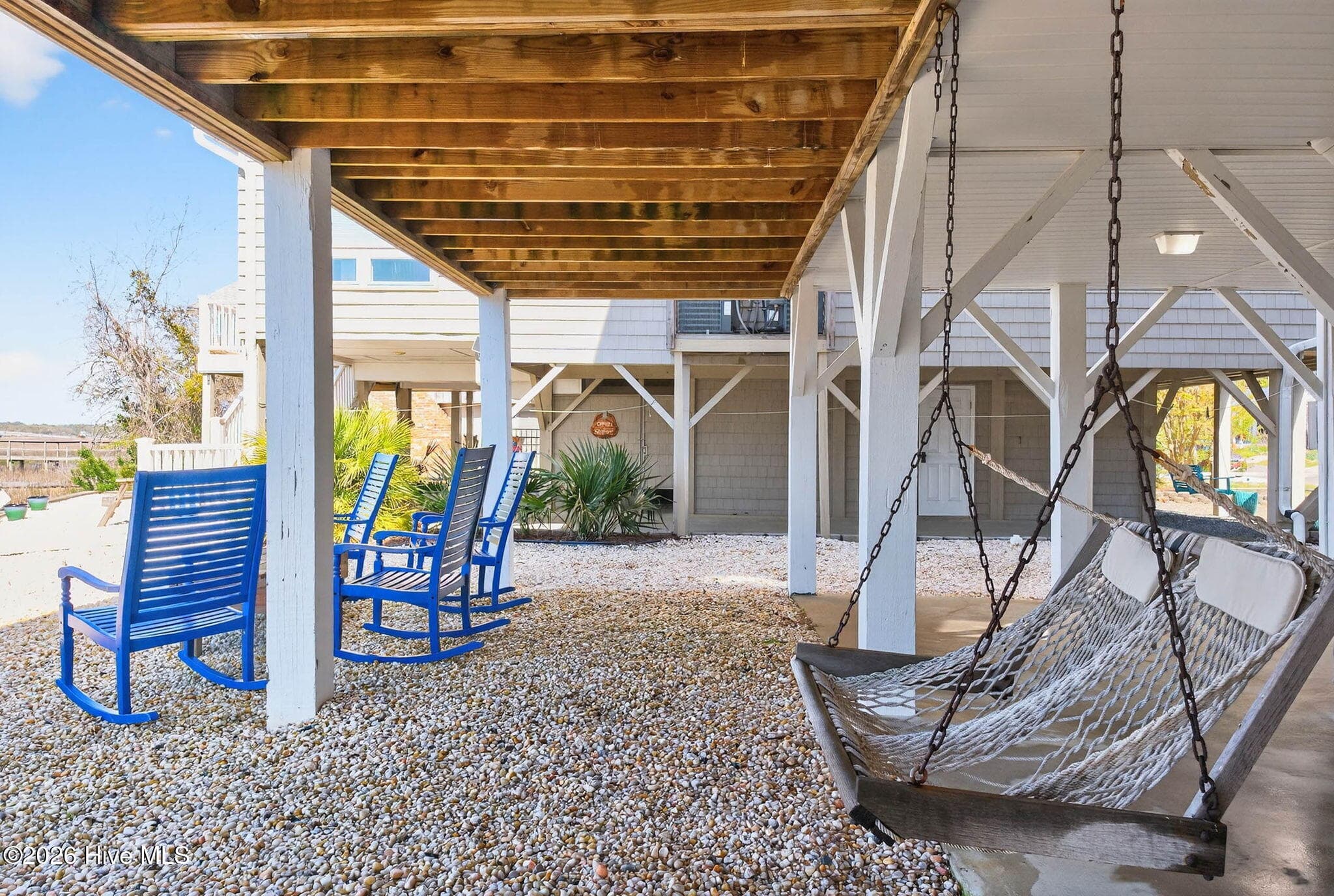 Covered ground-level area with seating and storage, ideal for coastal living and entertaining. - 1206 N Shore Drive W, Sunset Beach, NC 28468
