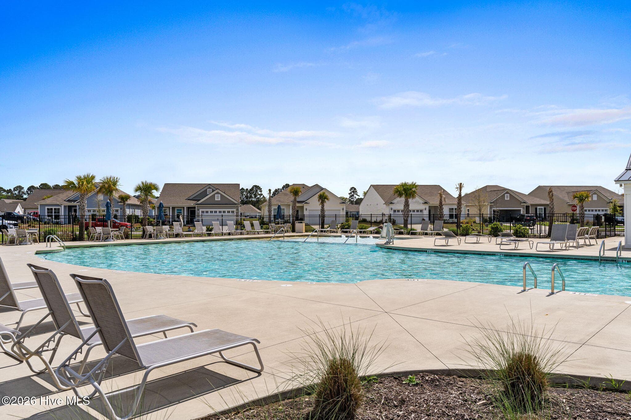 A spacious pool deck with lounge seating creates an inviting setting for residents to unwind and enjoy the Calabash lifestyle. - 139 Eagle Claw Drive, Calabash, NC 28467