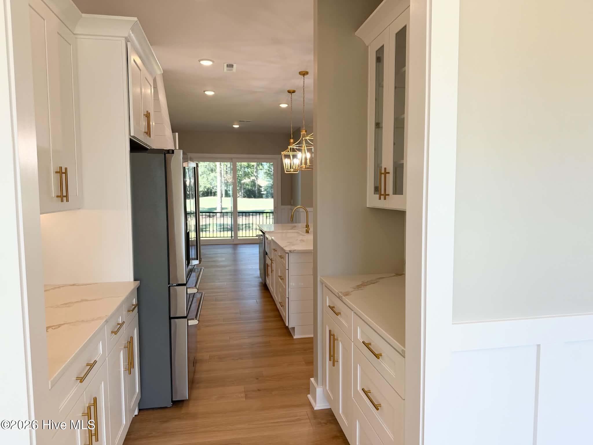 Looking at kitchen area from formal dining room. Custom lighting, counter tops, backsplash, faucet and cabinet hardware. - 550 Glenburnie Street NW, Calabash, NC 28467