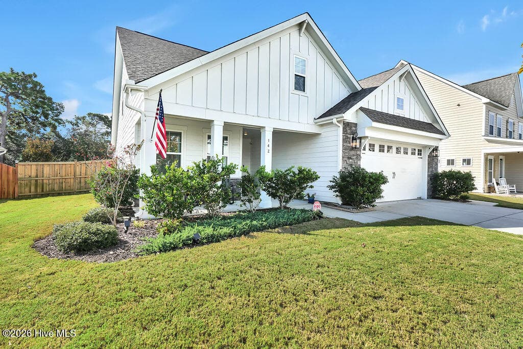 A fully irrigated yard and attractive landscaping make this front porch shine. - 142 Rice Marsh Way, Wilmington, NC 28412