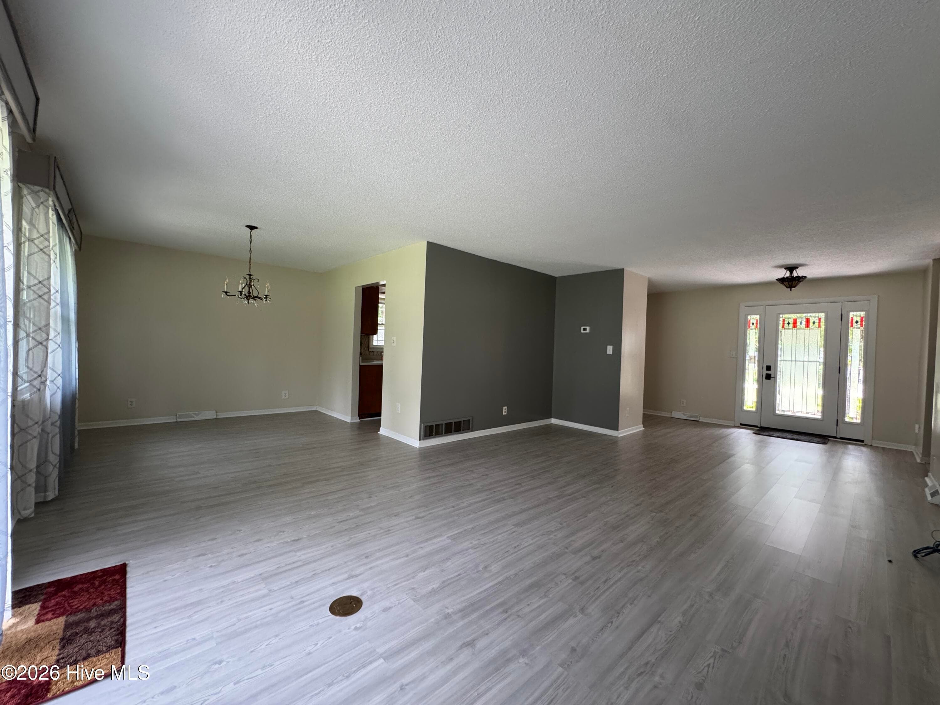 Entering through the Sliding Glass Doors into the Livingroom with a view of the Dining Room. (Notice the subsurface brass electrical connection). - 118 Oakwood Drive, Havelock, NC 28532