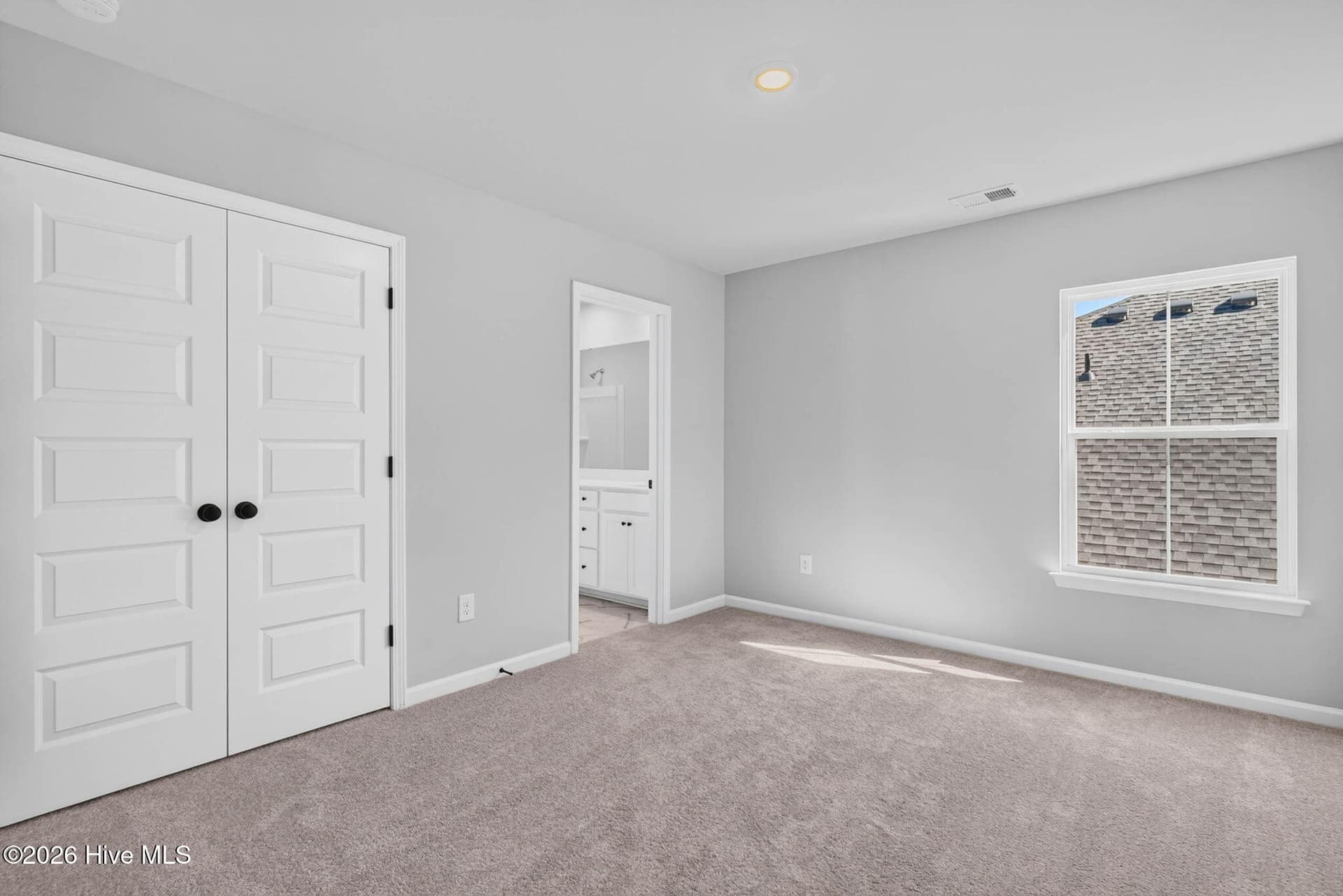 Comfortable upstairs bedroom with neutral finishes, carpeting, and natural light. - 3447 Sandhill Crane Drive SW, Ocean Isle Beach, NC 28469