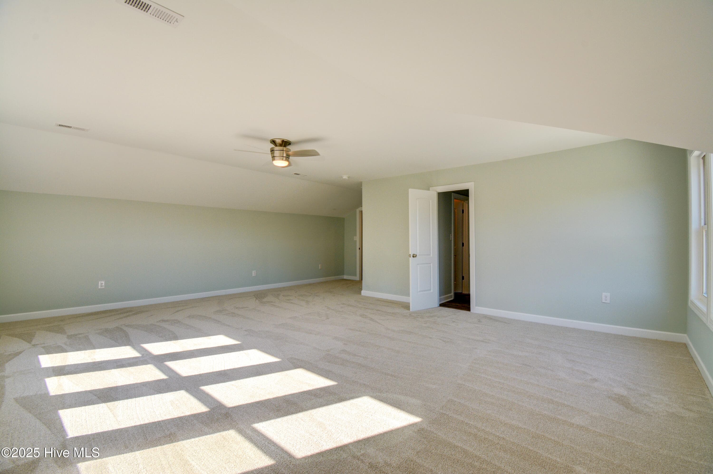 Large primary bedroom on main level with ceiling fan - 320 Belt Road, Hampstead, NC 28443