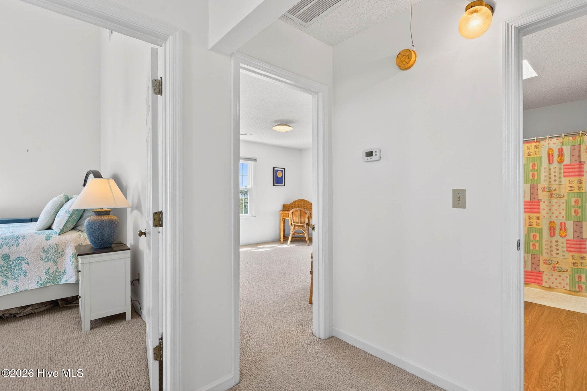 Bright interior hallway with easy access to bedrooms and shared living spaces. - 1206 N Shore Drive W, Sunset Beach, NC 28468