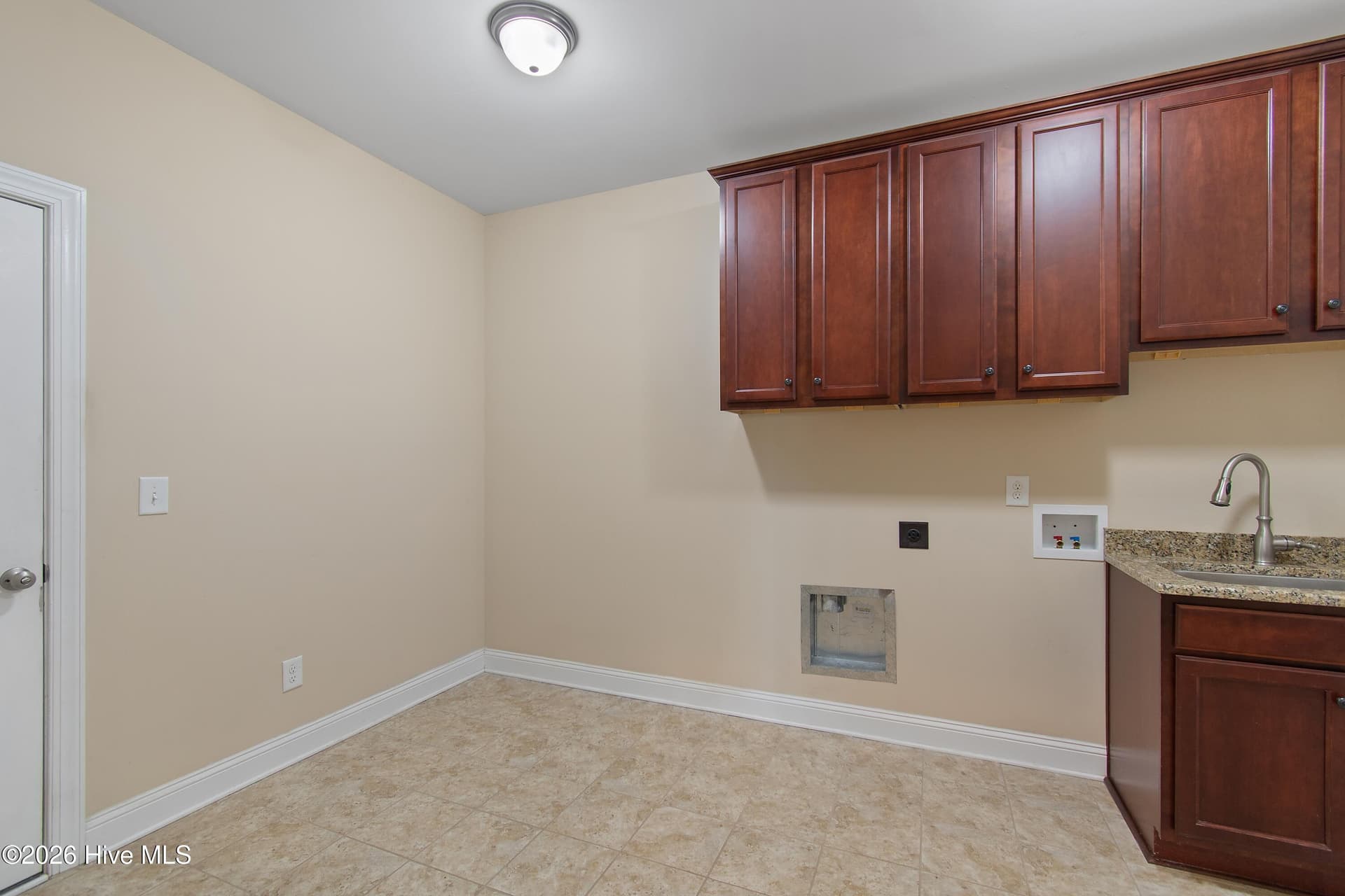 Laundry/utility room on first floor of home. Plenty of cabinets and a convenient utility sink. - 1674 Back Bay Drive SW, Shallotte, NC 28470