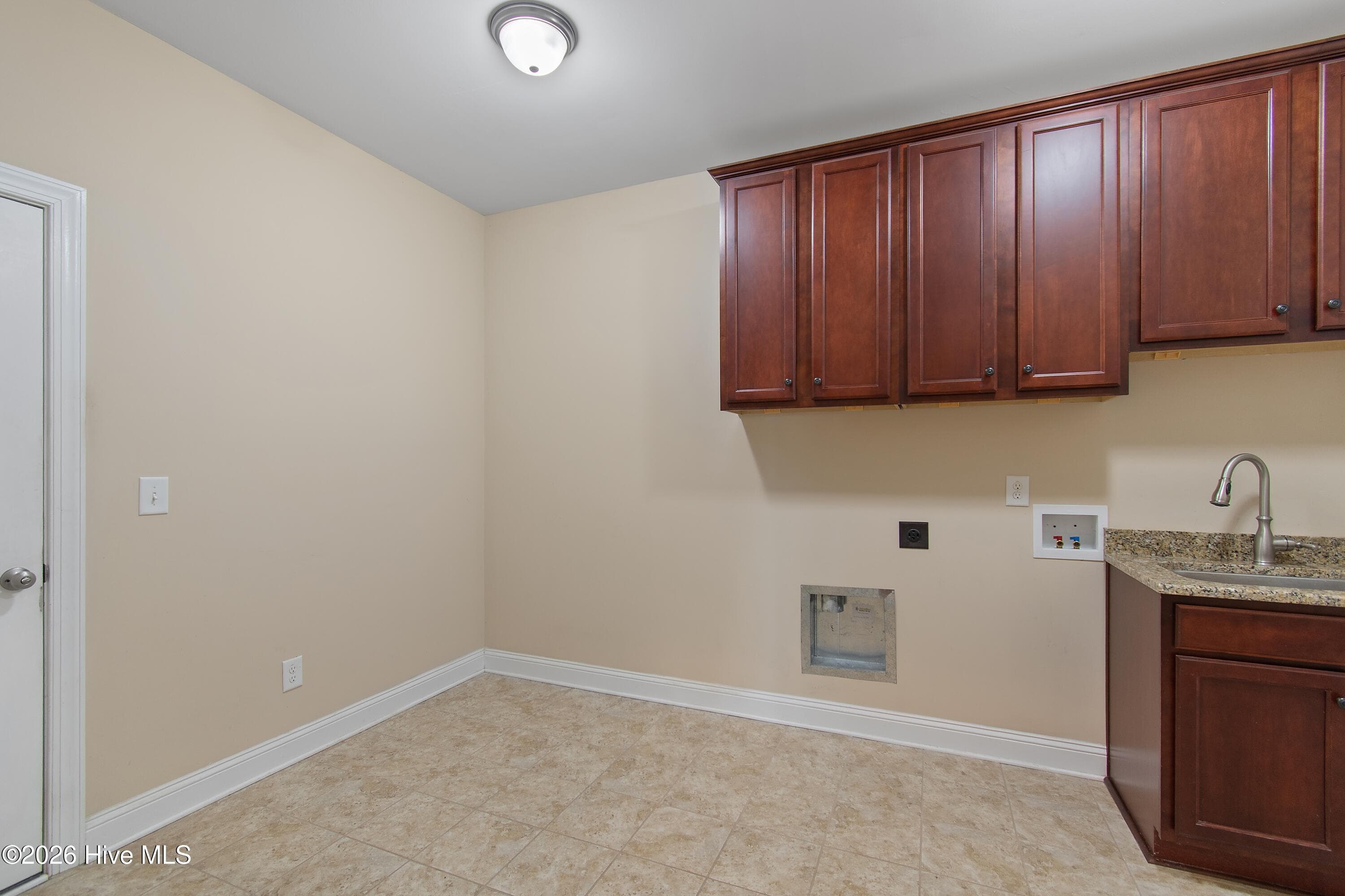 Laundry/utility room on first floor of home. Plenty of cabinets and a convenient utility sink. - 1674 Back Bay Drive SW, Shallotte, NC 28470