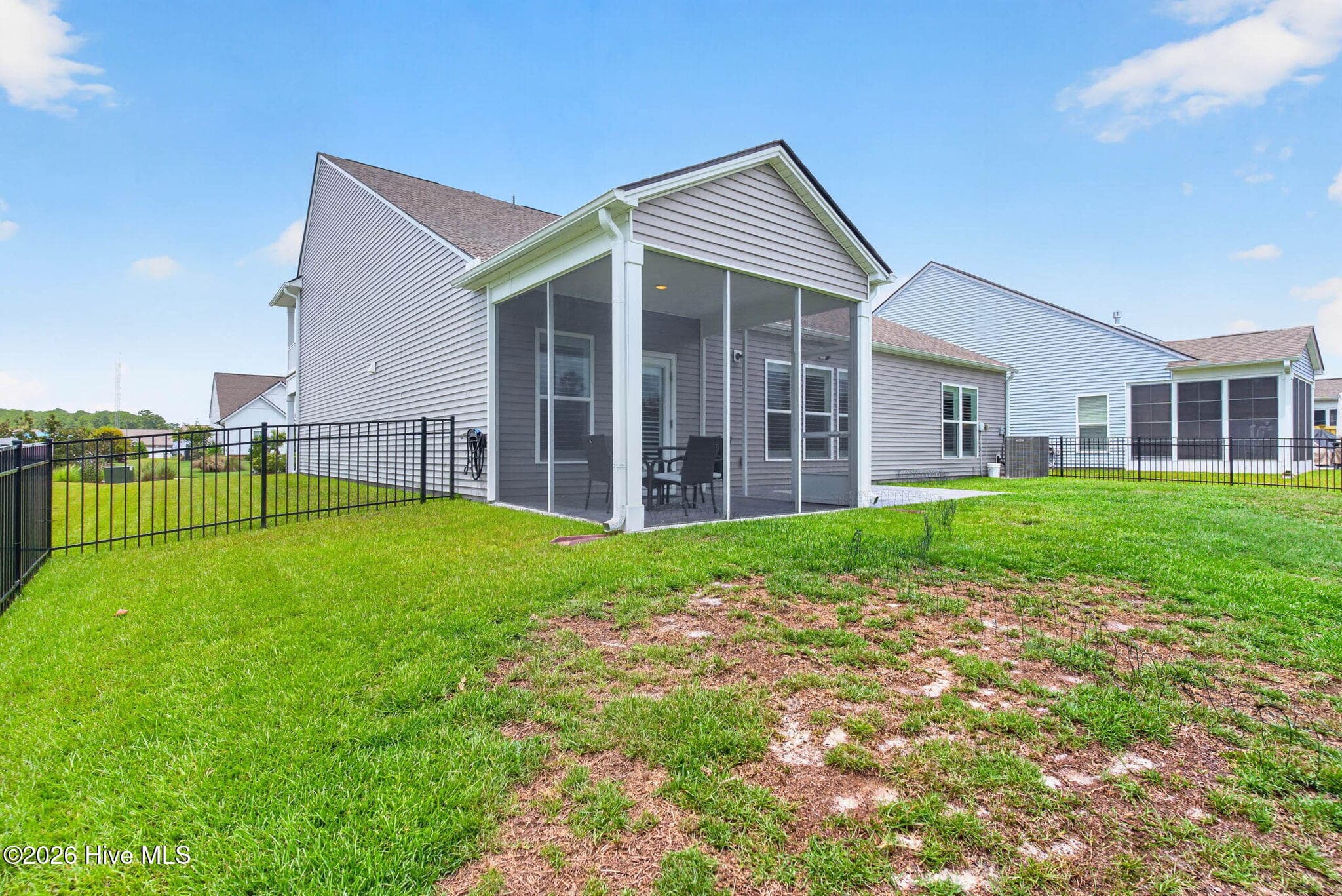 The rear exterior highlights the screened porch, patio, fenced backyard, and golf-course setting. - 139 Eagle Claw Drive, Calabash, NC 28467