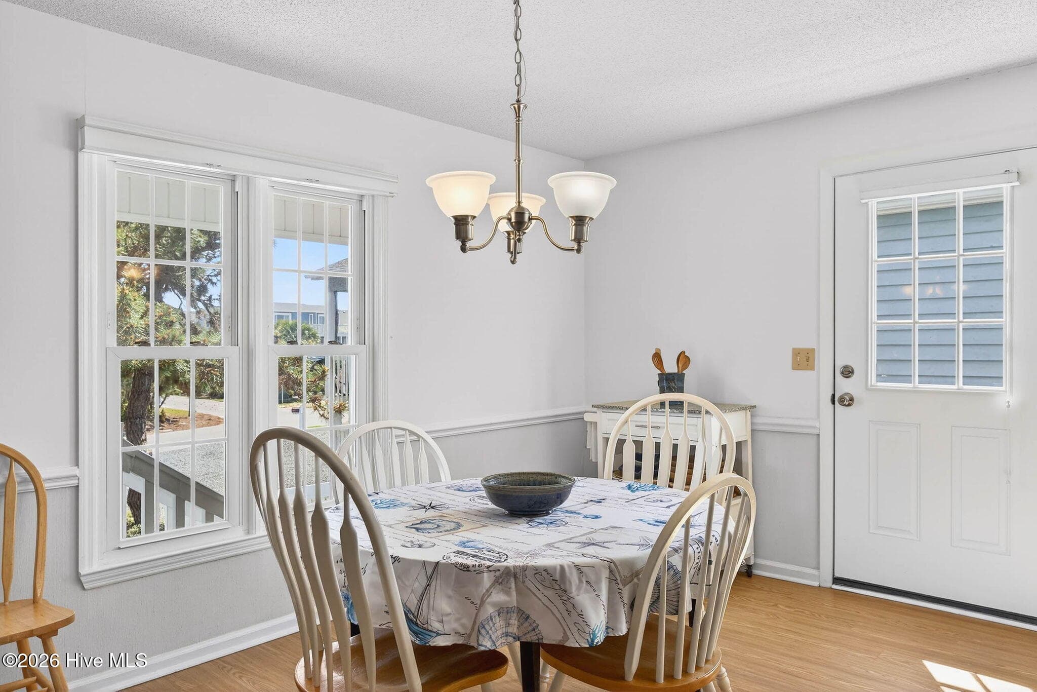Bright dining space with large windows and access to outdoor decking. - 1206 N Shore Drive W, Sunset Beach, NC 28468