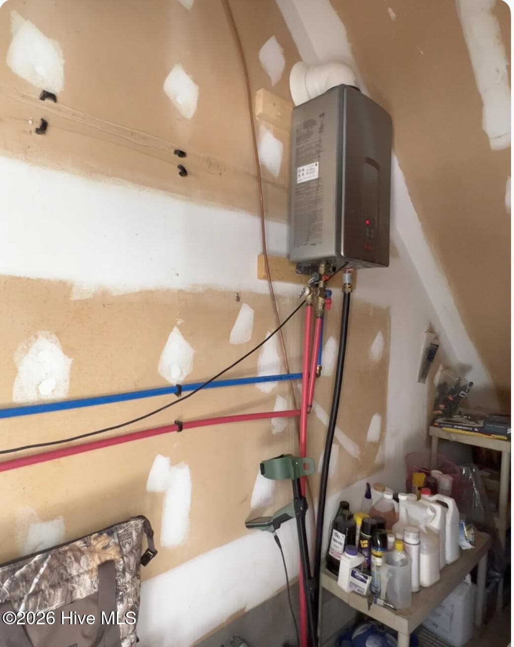 Storage closet in Garage showing the On Demand Gas Water Heater. - 642 Enoch Road, Clinton, NC 28328