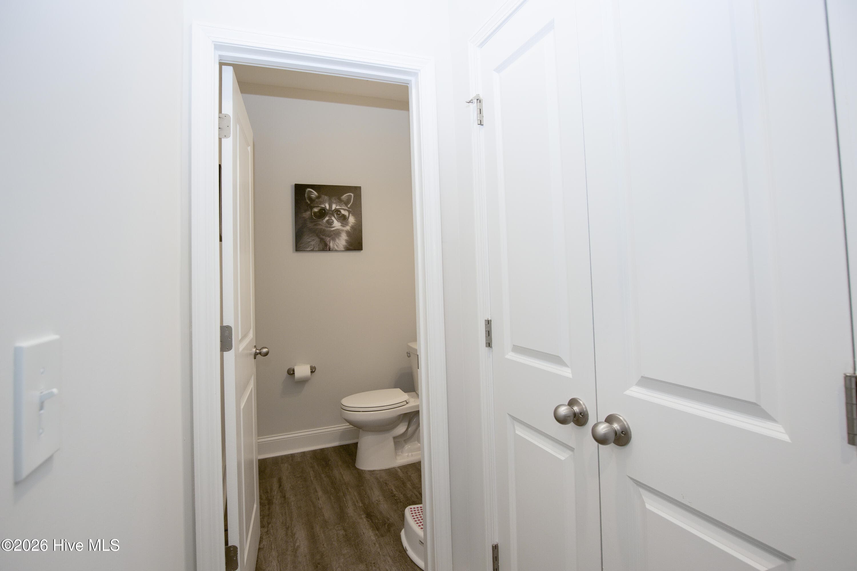 Along the main-level hall, the half bath sits beside a double-door linen closet. Guests can reach the powder room without passing through the kitchen or going upstairs. Placing it near the front of the house also keeps it close to the flex room. - 221 Vega Lane, Linden, NC 28356