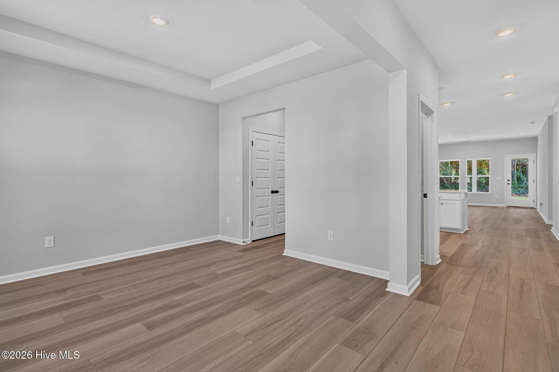 Spacious formal dining room with elegant trim detailing, natural light, and luxury vinyl plank flooring. - 3447 Sandhill Crane Drive SW, Ocean Isle Beach, NC 28469